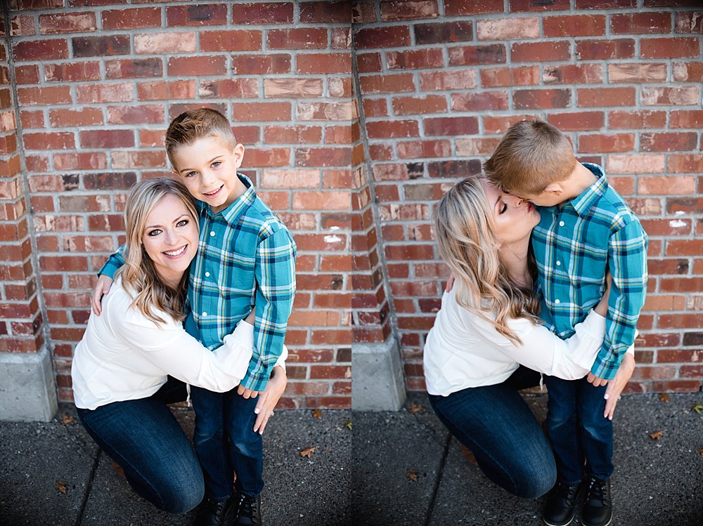  mother and son embrace in front of a brick wall in the Old Mill District in Bend 