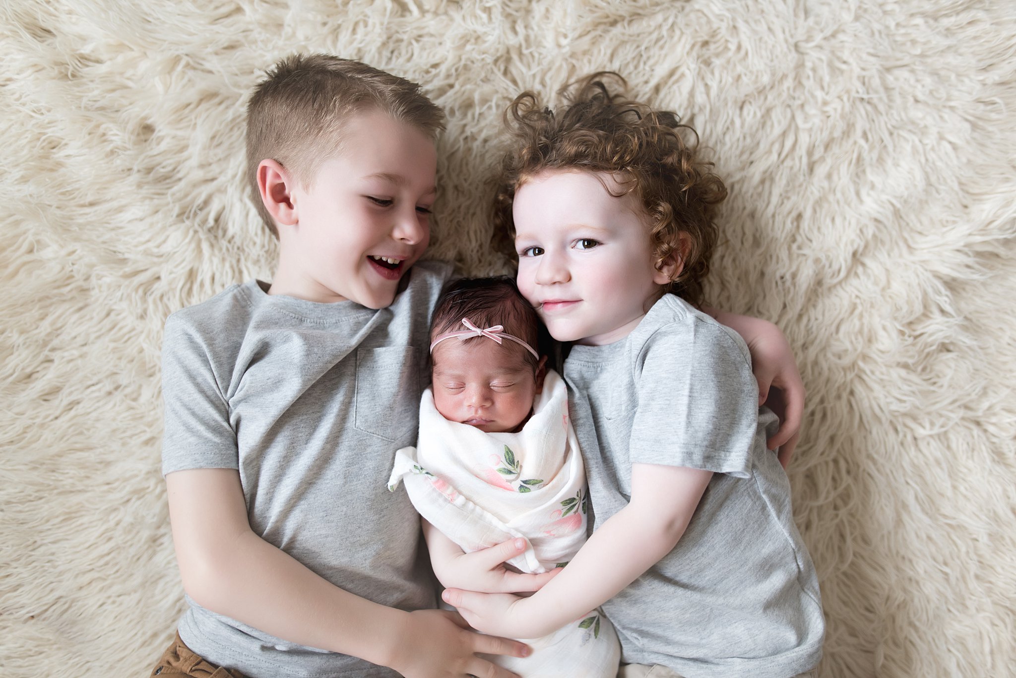  brothers lay together with their new baby sister between them 