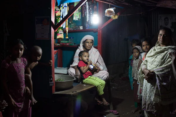 Residents gather around the local store with light