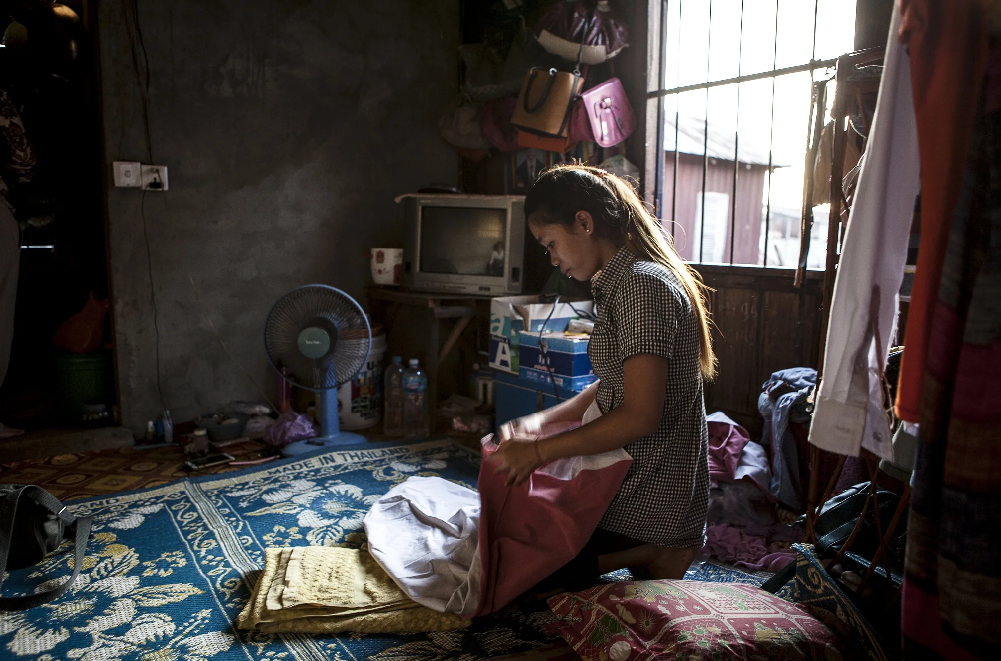 A garment work sits in her room