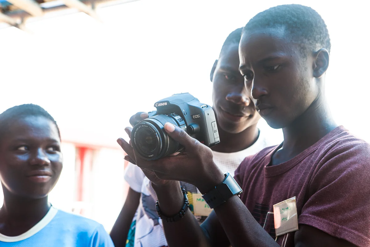 Jamiu holding the camera in photograhy class.