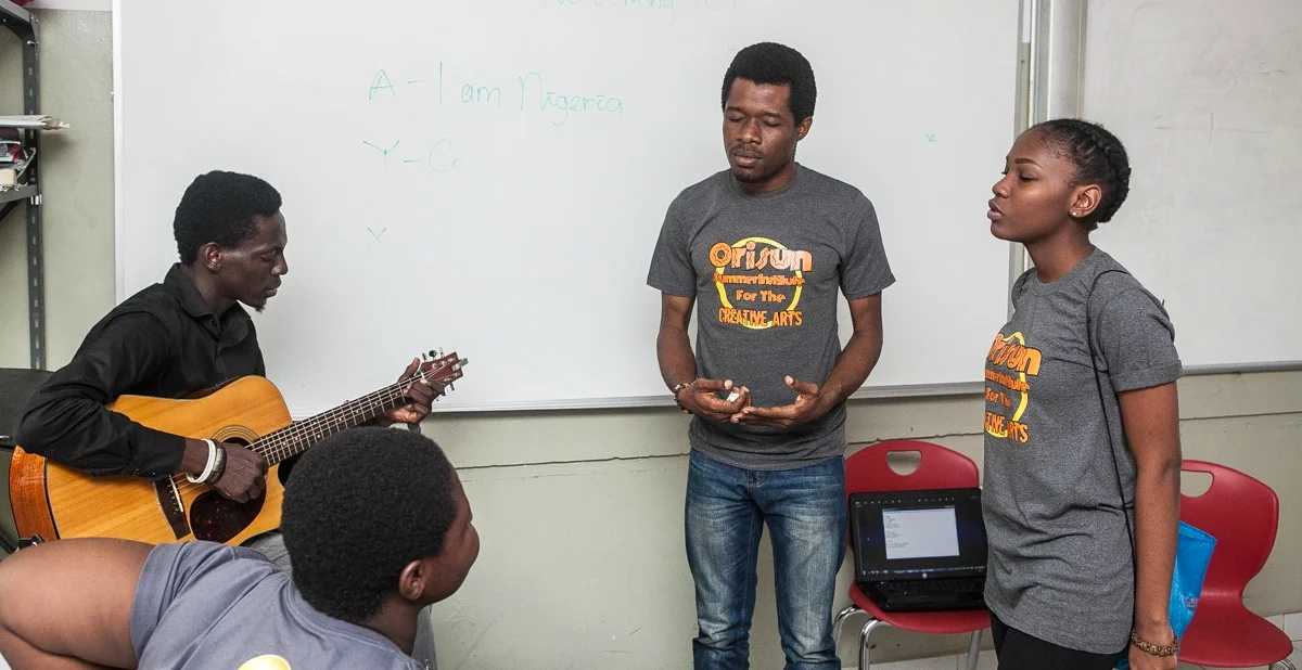 Edward working with GUITARIST AND osica students during singing class.