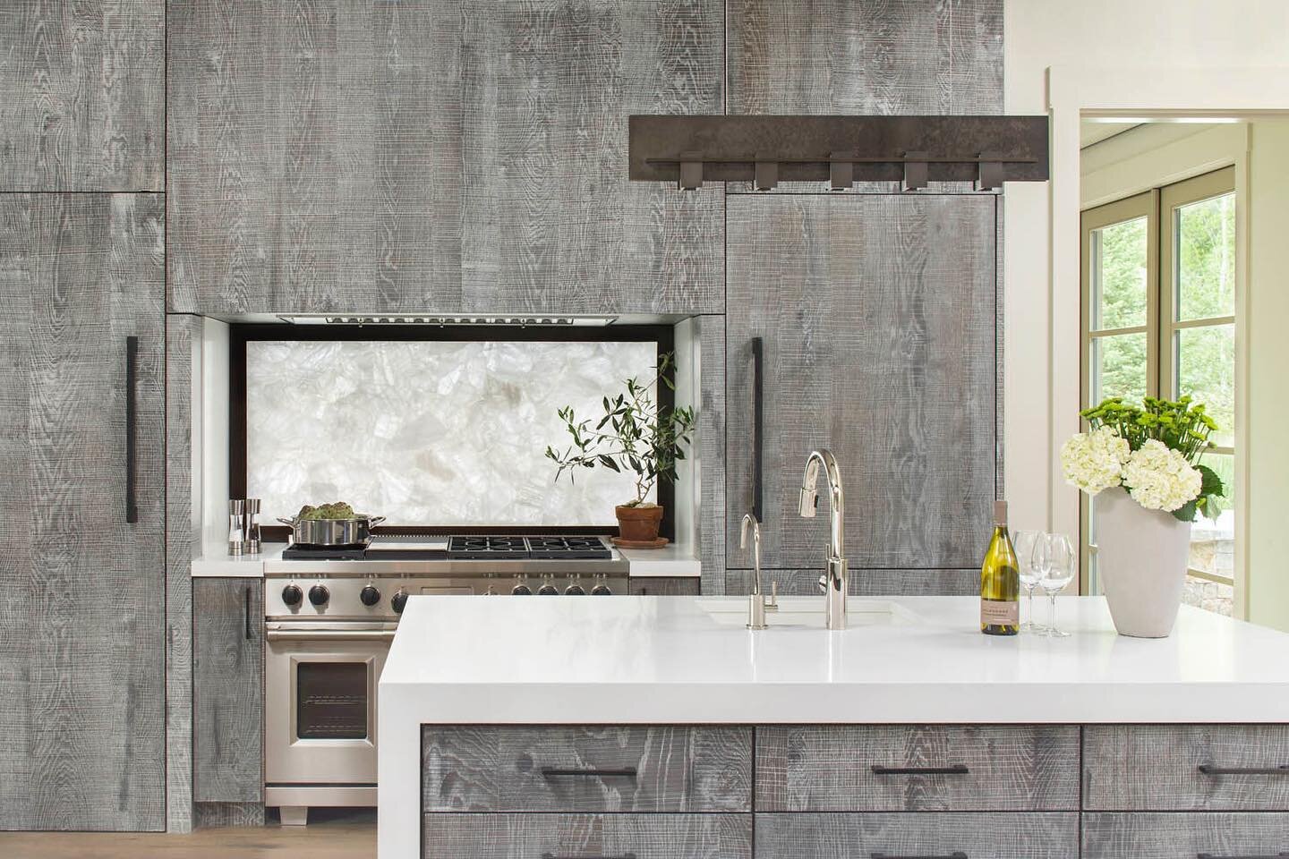 This modern kitchen showcases rustic, gray wood cabinets that frame a stunning crystal backsplash. Clean, yet warm: perfect for entertaining. 
Cabinetry: @sanctuarykitchenandbath 
Photography: @berlygavin 

#timelessdesign 
#kitchensofinstagram 
#mod