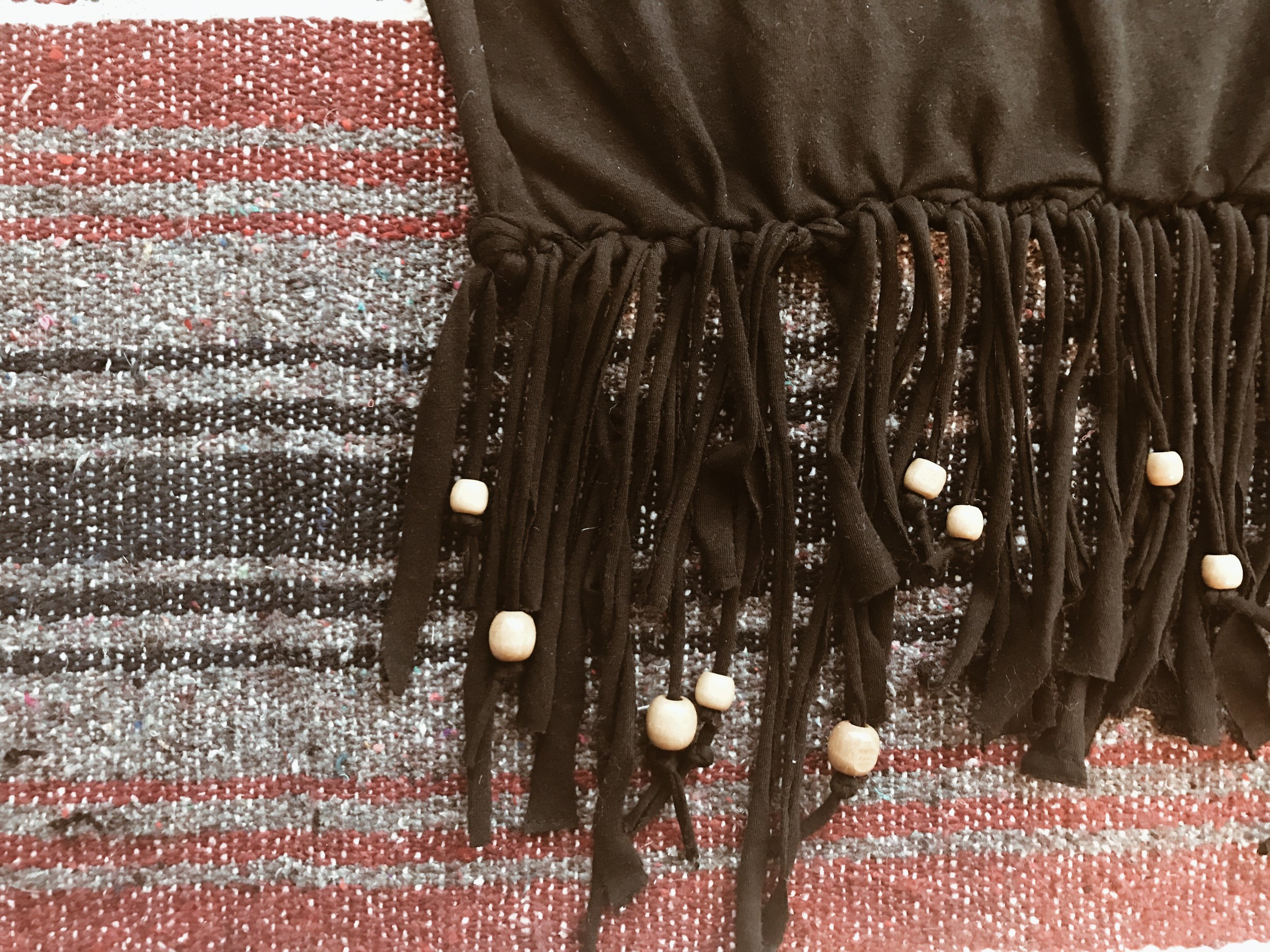 Embellish your bag by adding beads to the bottom fringe! Wooden beads are my favorite, but you can use any kind! Simply slip them on, and tie a knot at the bottom of the strip so the bead stays on! 