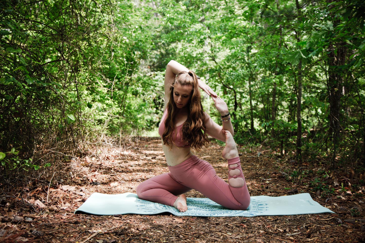 Mermaid — While in "Pigeon Pose" reach back with your right hand towards the right foot. Begin to bend the elbow and place the right foot into the elbow crease. Inhale, reach the left hand up and overhead to interlock hands. 