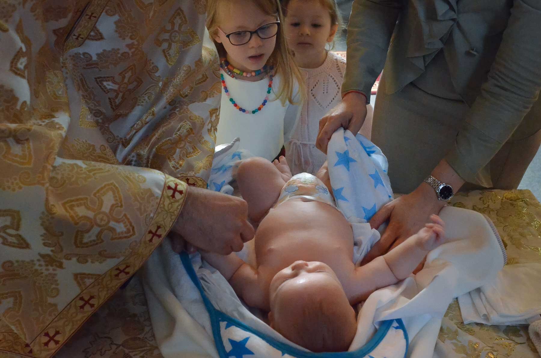  An Orthodox christening. These are elaborate and beautiful ceremonies. I love the way the little girls are looking on.  