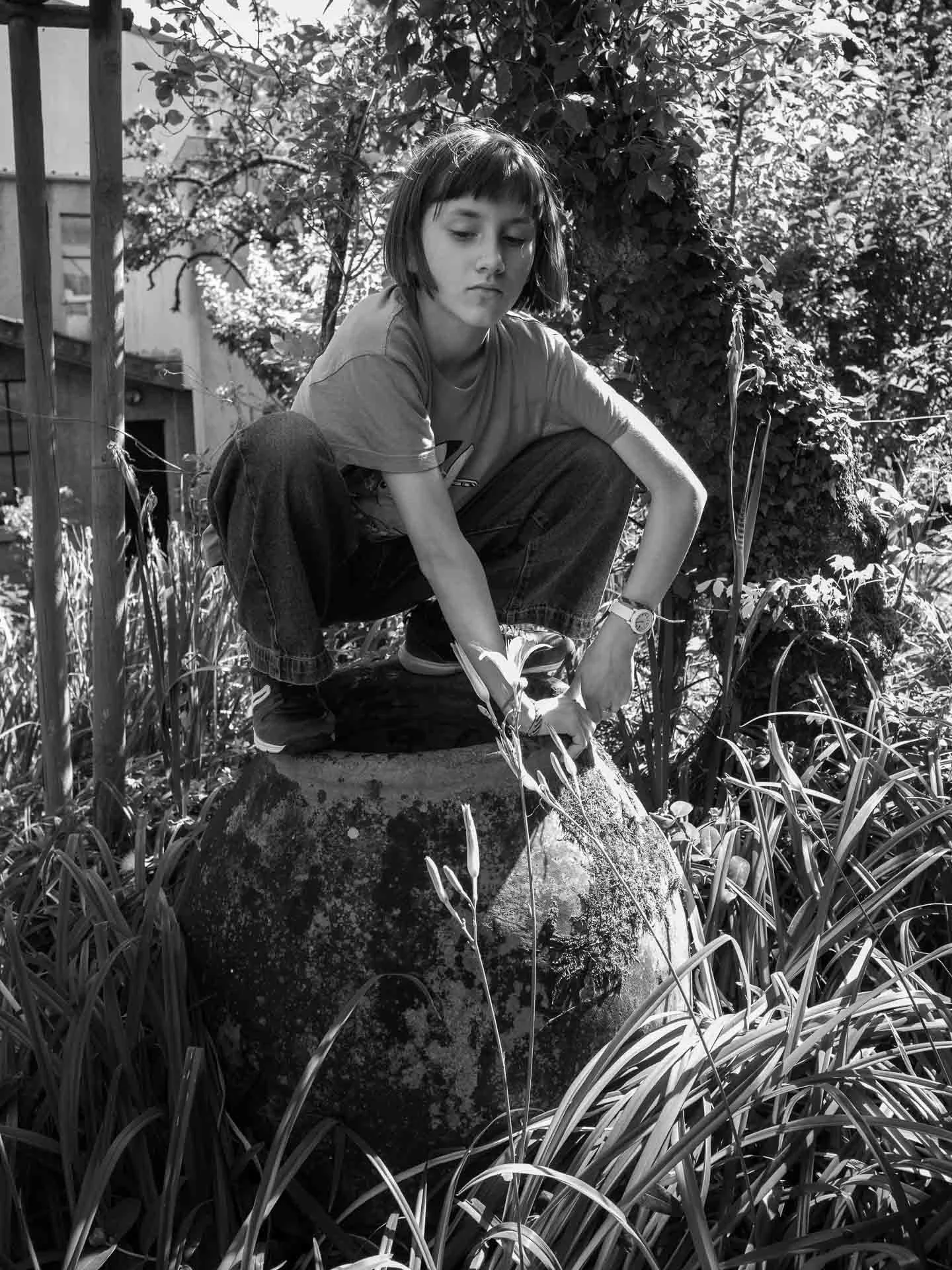  Girl nicely balanced on a large garden pot 