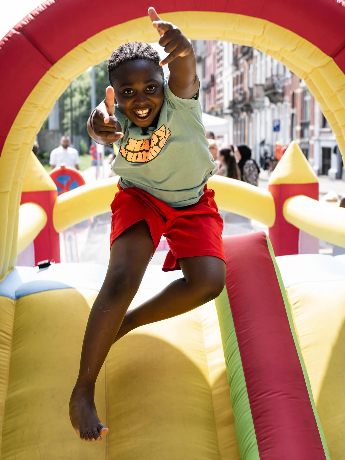  A boy launches himself from the upper storey of a bouncy castle 