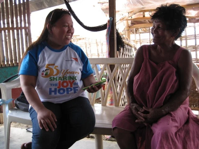 A World Vision member of staff with a community member. Credit: World Vision