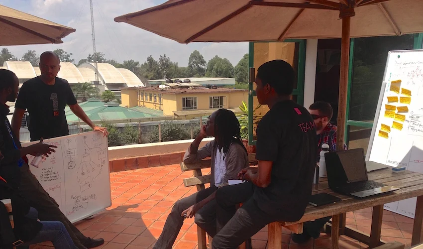The dev team in one of our design meetings. Post-its, whiteboards, sun and debate.