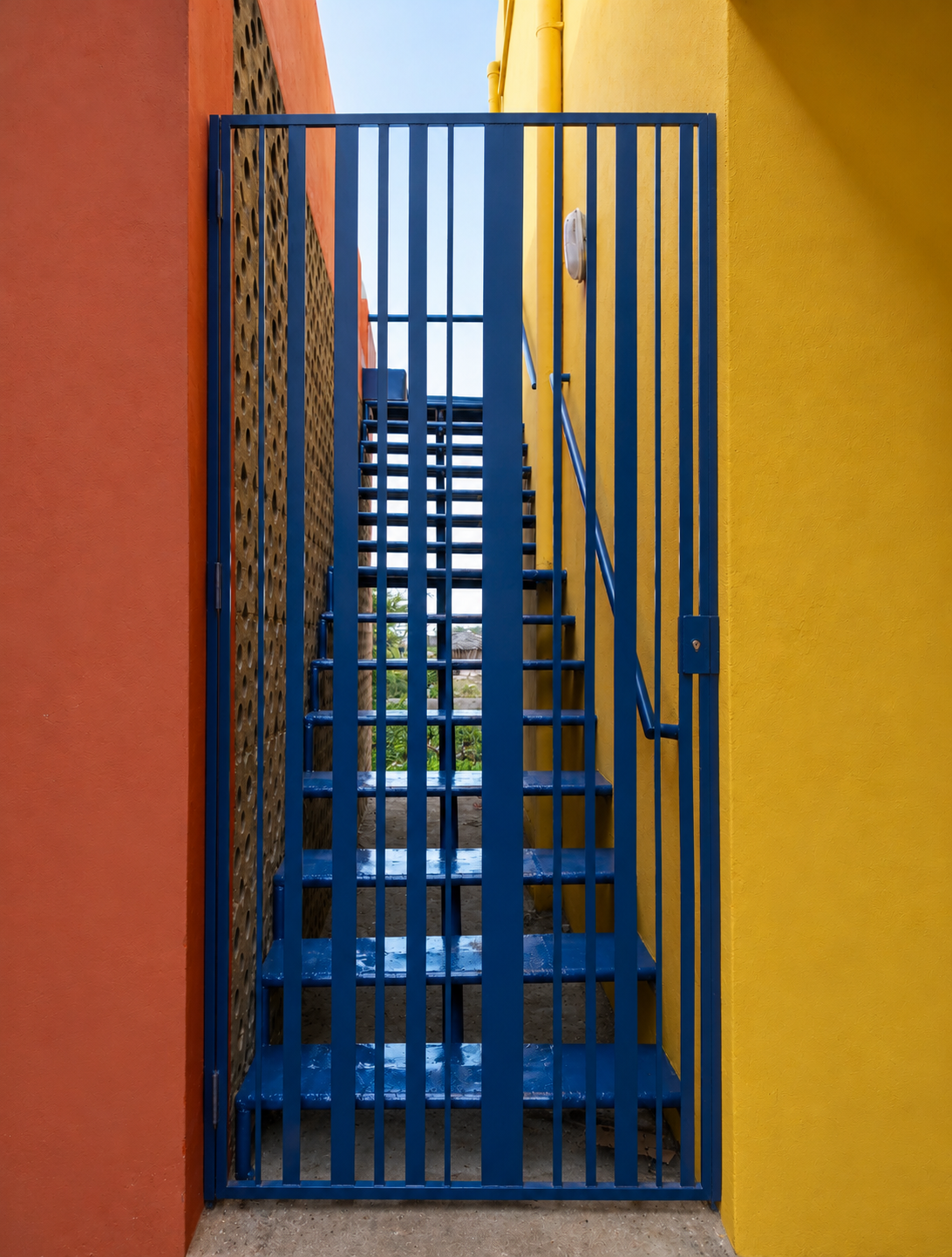Cancello blu tra muri colorati.png