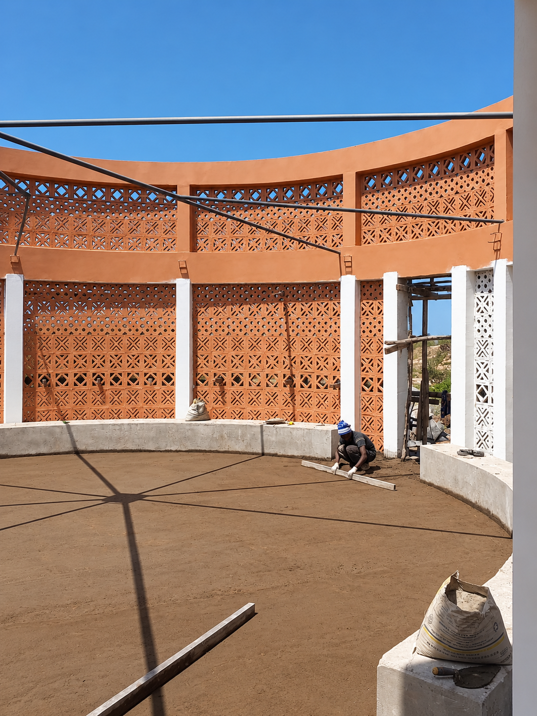 Cantiere circolare in terracotta sotto il cielo blu.png