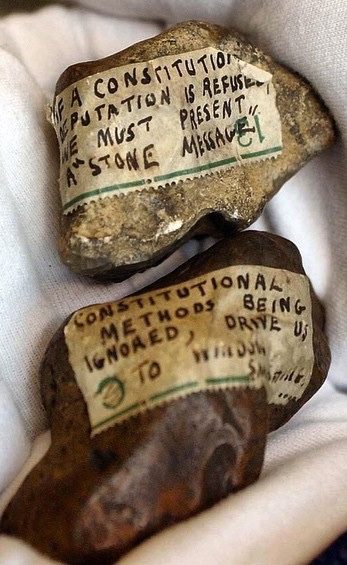 Stones Thrown 1908, Stone, Paper, Ink, Shellac "At a mass rally in Hyde Park, 300,000 to 500,000 activists attend. The Liberal Prime Minister Herbert Asquith does not respond. To get his attention, suffragettes smash windows in Downing Street, using stones with written pleas tied to them. Some protesters chain themselves to railings." - The Guardian