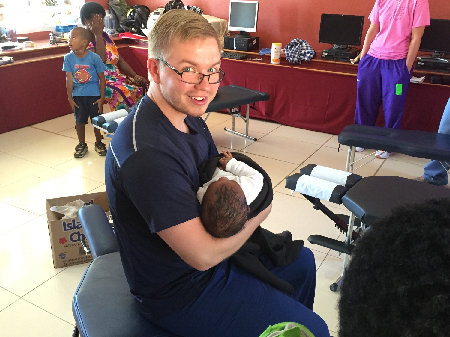 Dr. Alex Wolfe of Wolfe Family Chiropractic Metamora with infant in outreach clinic