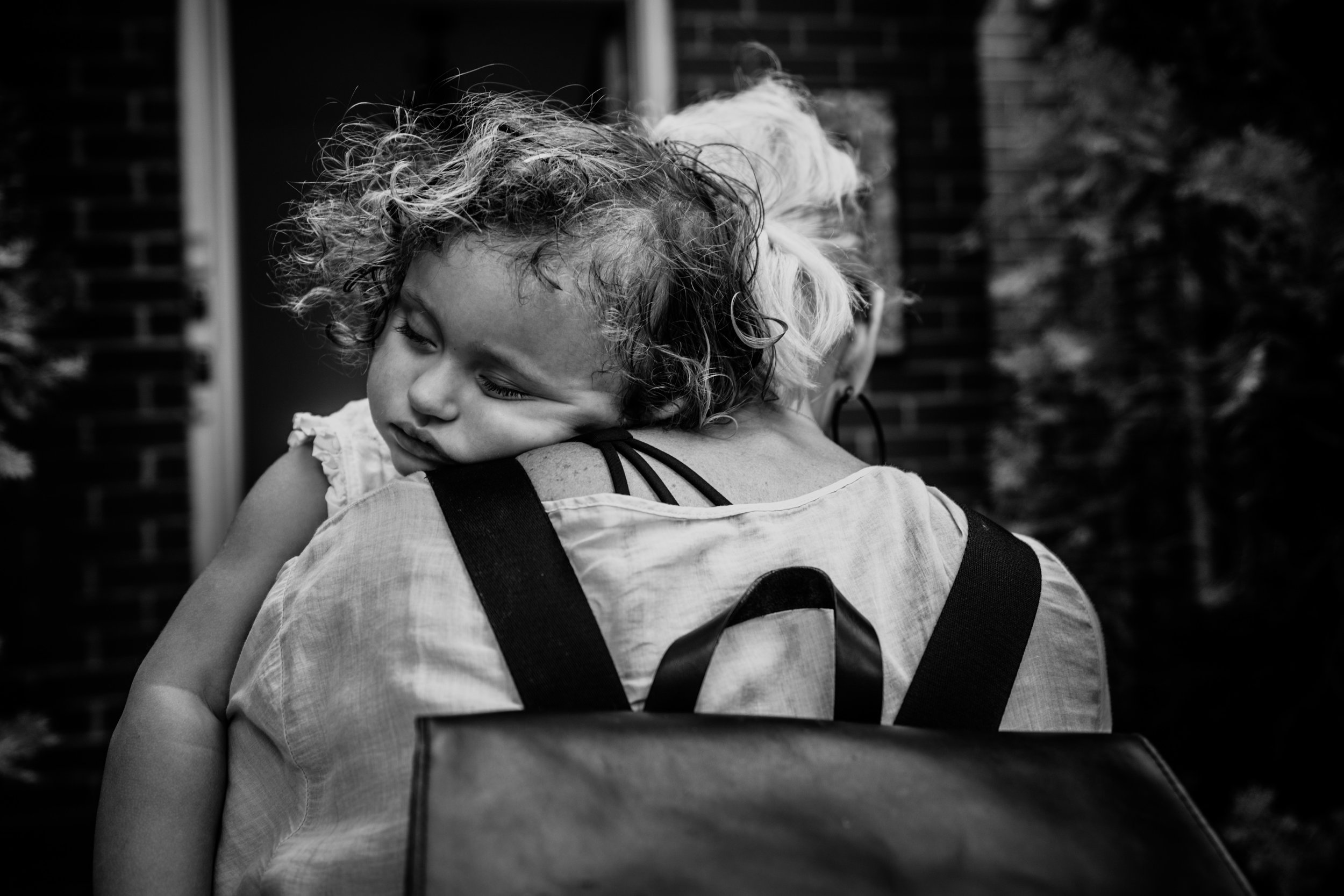 Mom carrying sleeping daughter