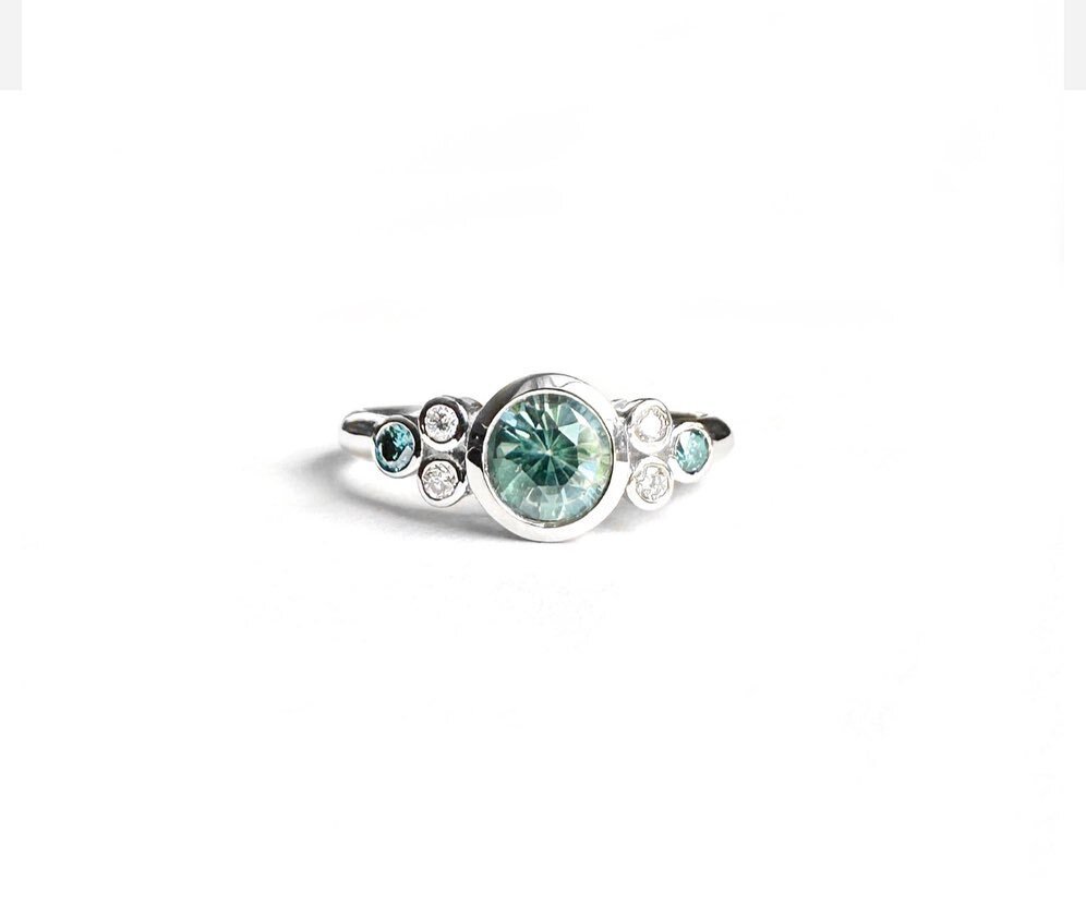 I always love how unique and one-of-a-kind each Montana sapphire is, just like this 0.75ct color changing teal-blue beauty, and my client suggested adding something blue to complement the center stone, so we used two blue diamonds for this ring, look