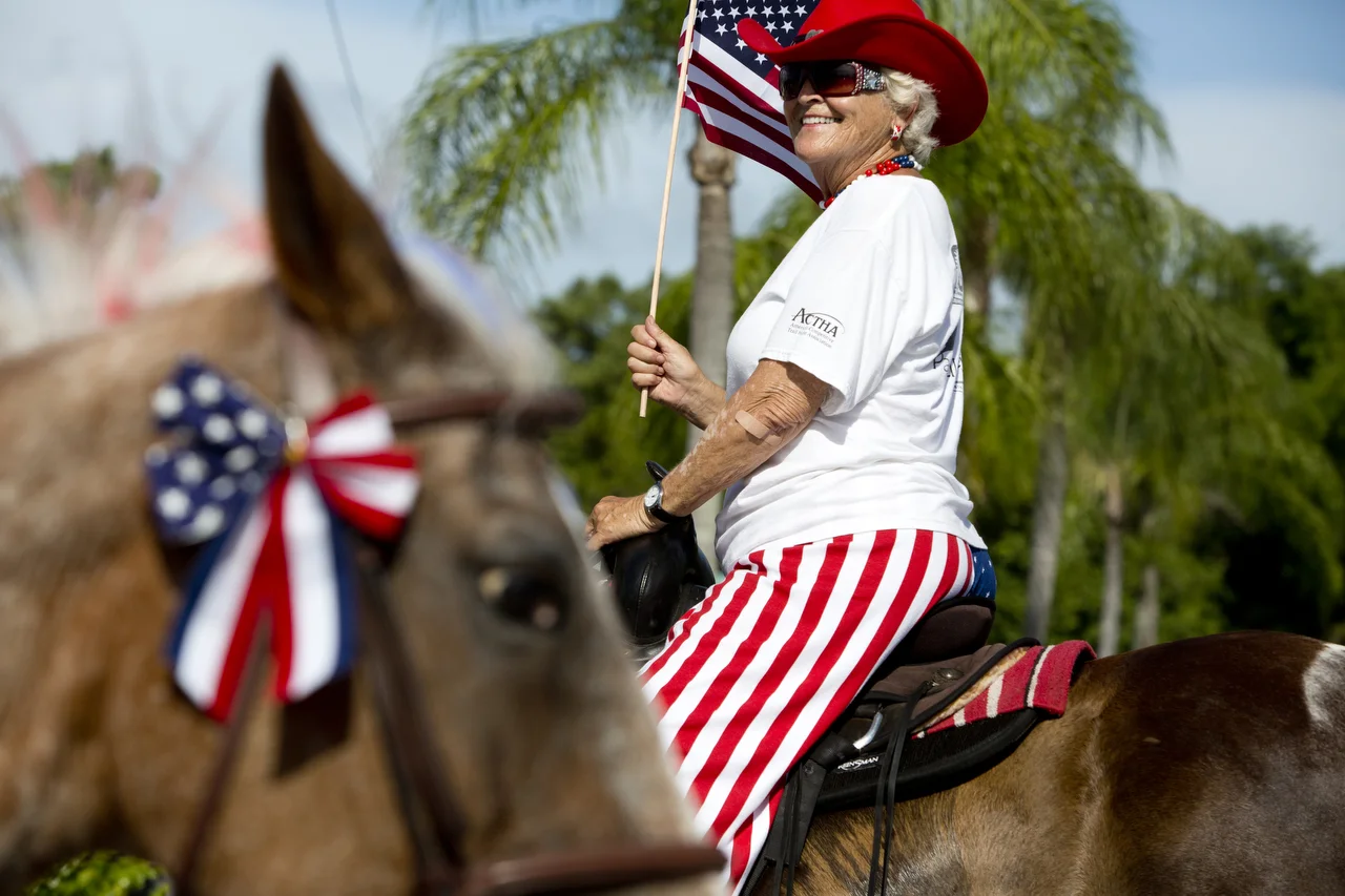  Lynda Rehse rides her horse Tonto while waving a flag during the Bonita Springs parade on July 4, 2016. 