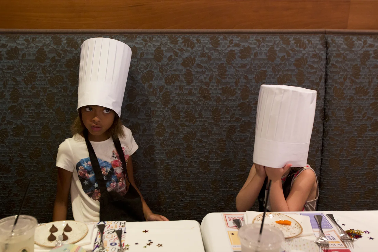  6-year-old Andrea Oscarsson, left, and 6-year-old Anabella Frey, right, sit while waiting for their meals during a kids cooking class at Sea Salt in Naples on June 25, 2016. 