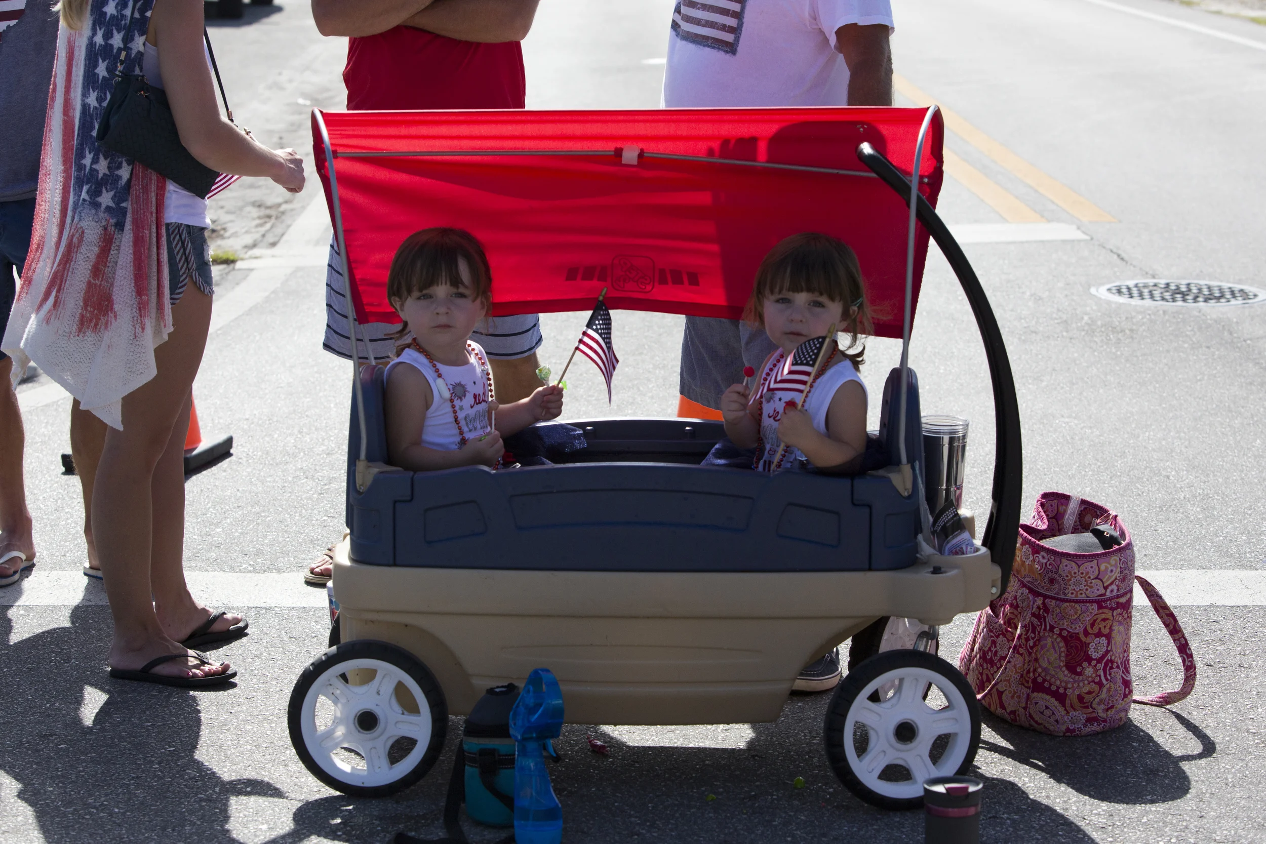  2-year-old twins Madeline Hicks, left, and Sophia, sit in a wagon during the Bonita Springs parade on July 4, 2016. 