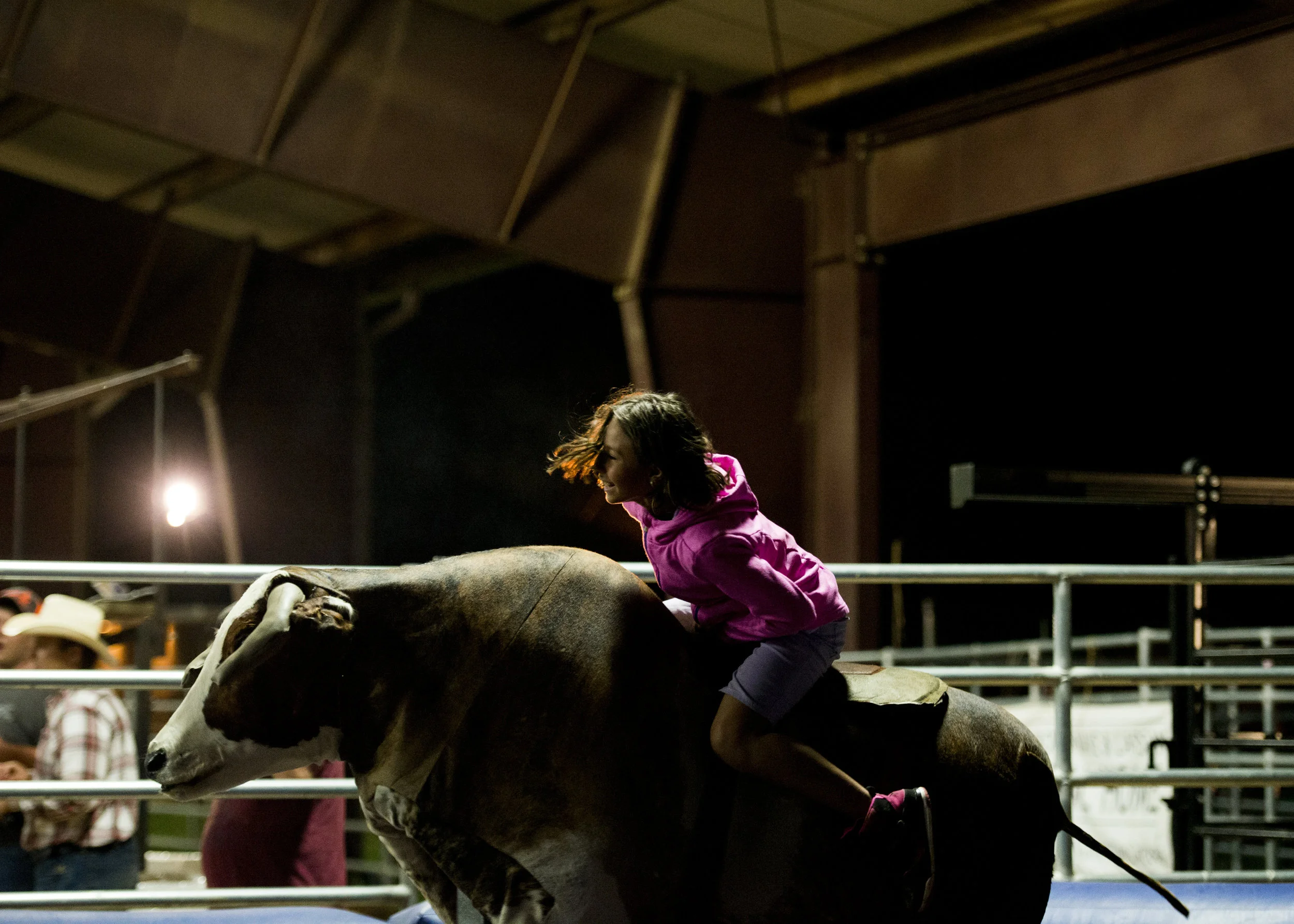  Natalie Schreiber-Rivera, 8, laughs while riding the mechanical bull at the Kiwanis Rodeo. 