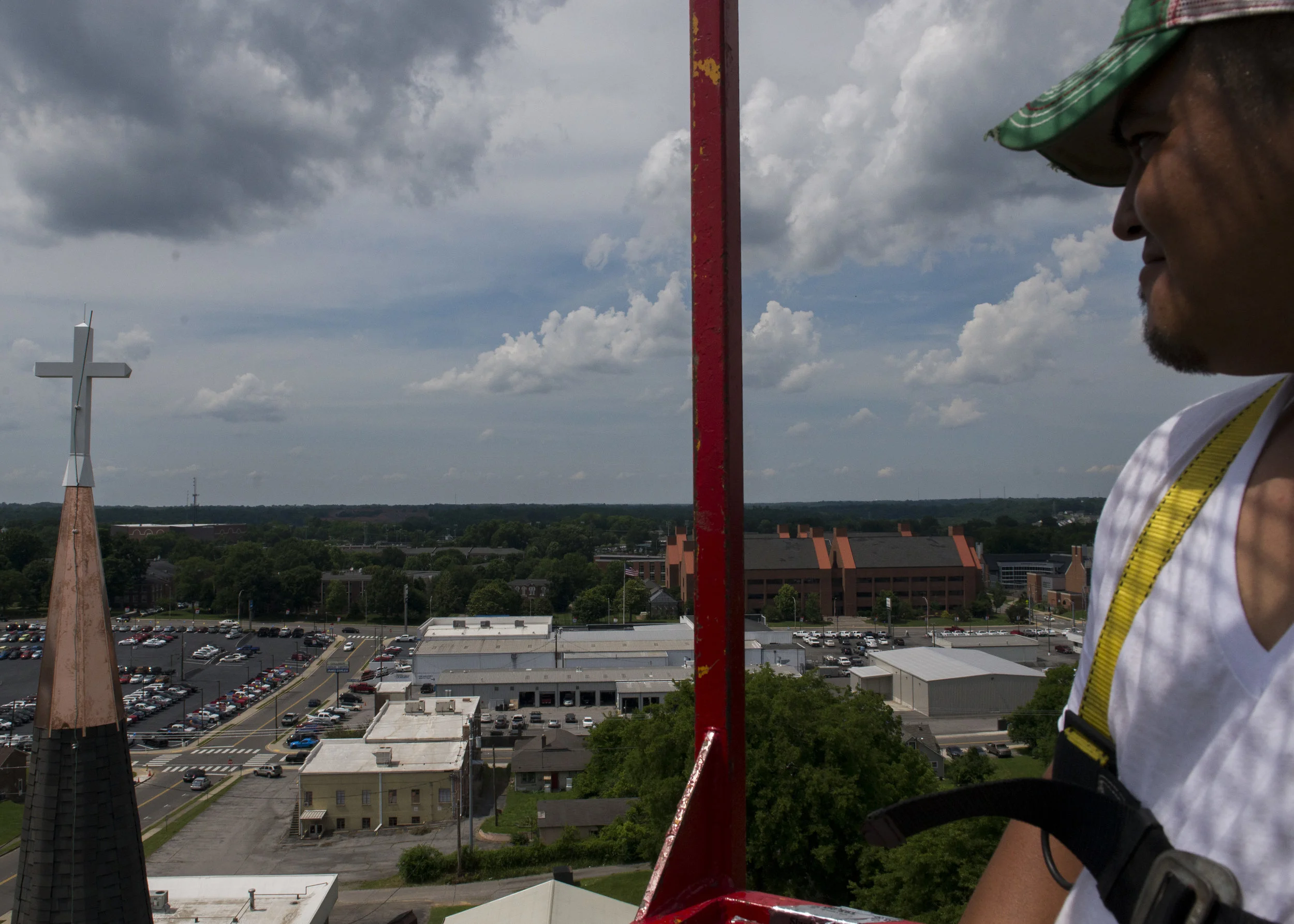  A worker smiles as he looks at the new cross placed at the top of Immaculate Conception Catholic Church in Clarksville on June 1, 2017. 