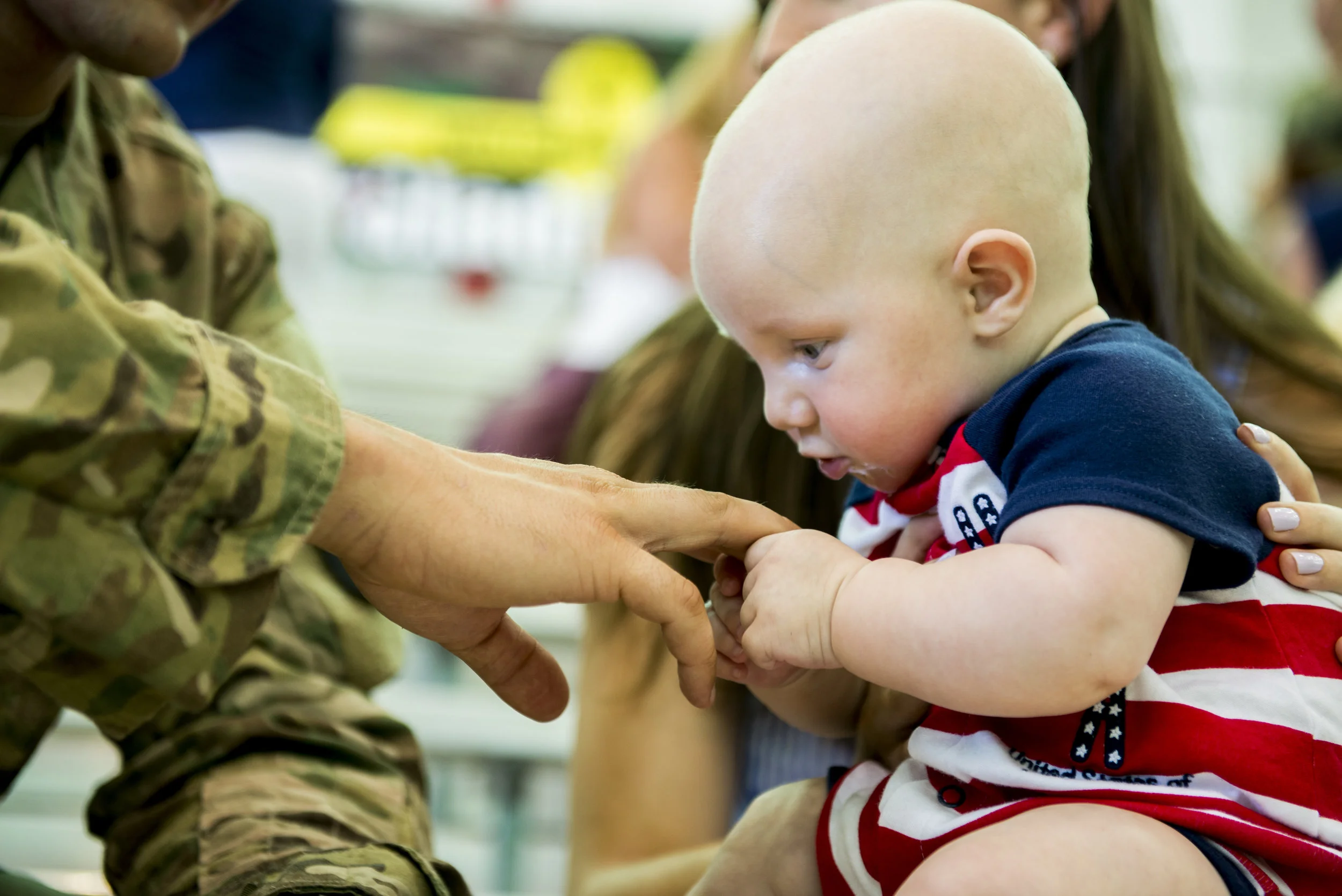  Clark Sweeney holds his father's hand for the first time after a 9-month deployment in Afghanistan. 