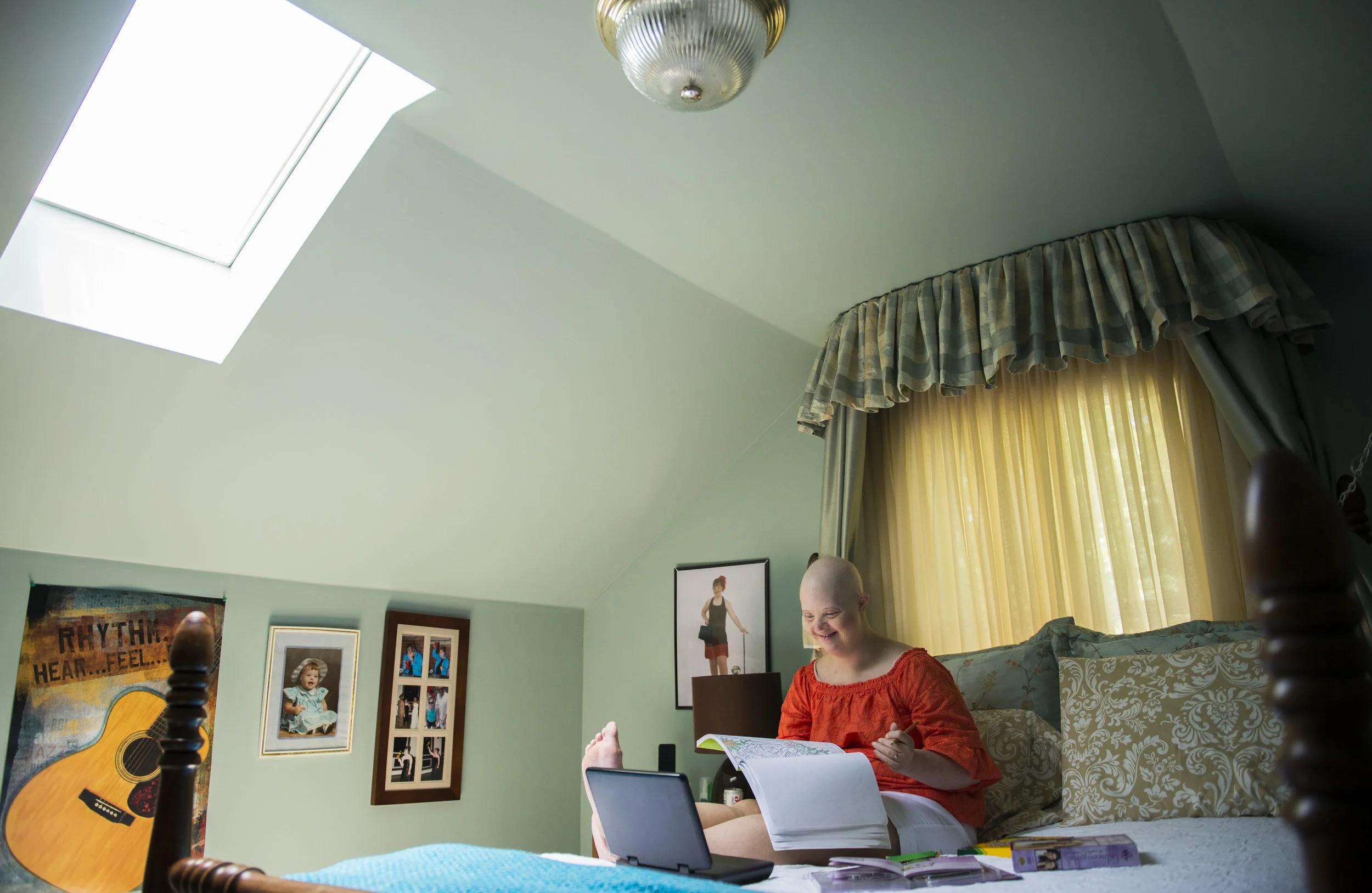  Katie smiles as she watches Gilmore Girls and colors in her bedroom at home. 