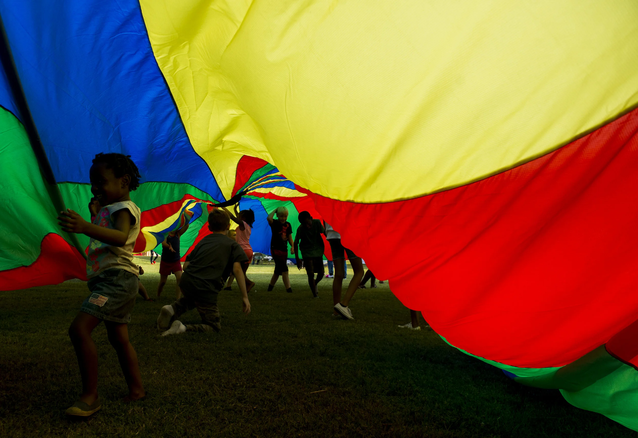  Kids run under a parchute during Clarksville's Summer Night Lights on July 24, 2017. 