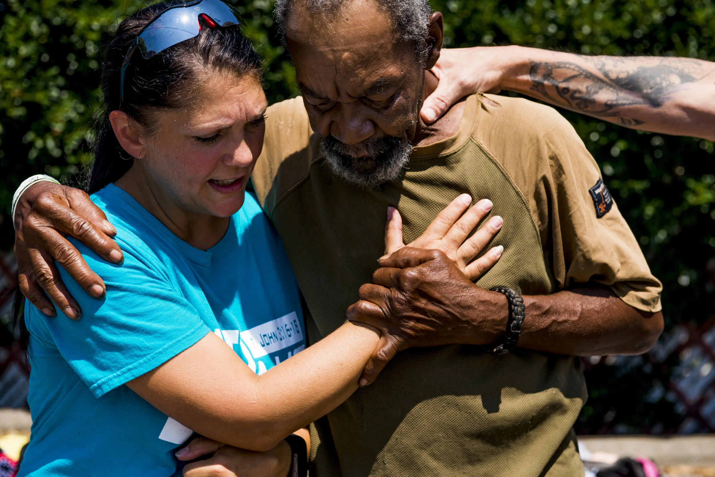  YAIPak Outreach Founder Sherry Nicholson holds Coolbreeze as she says a prayer for him during a shop she set up for the homeless on August 2, 2017 