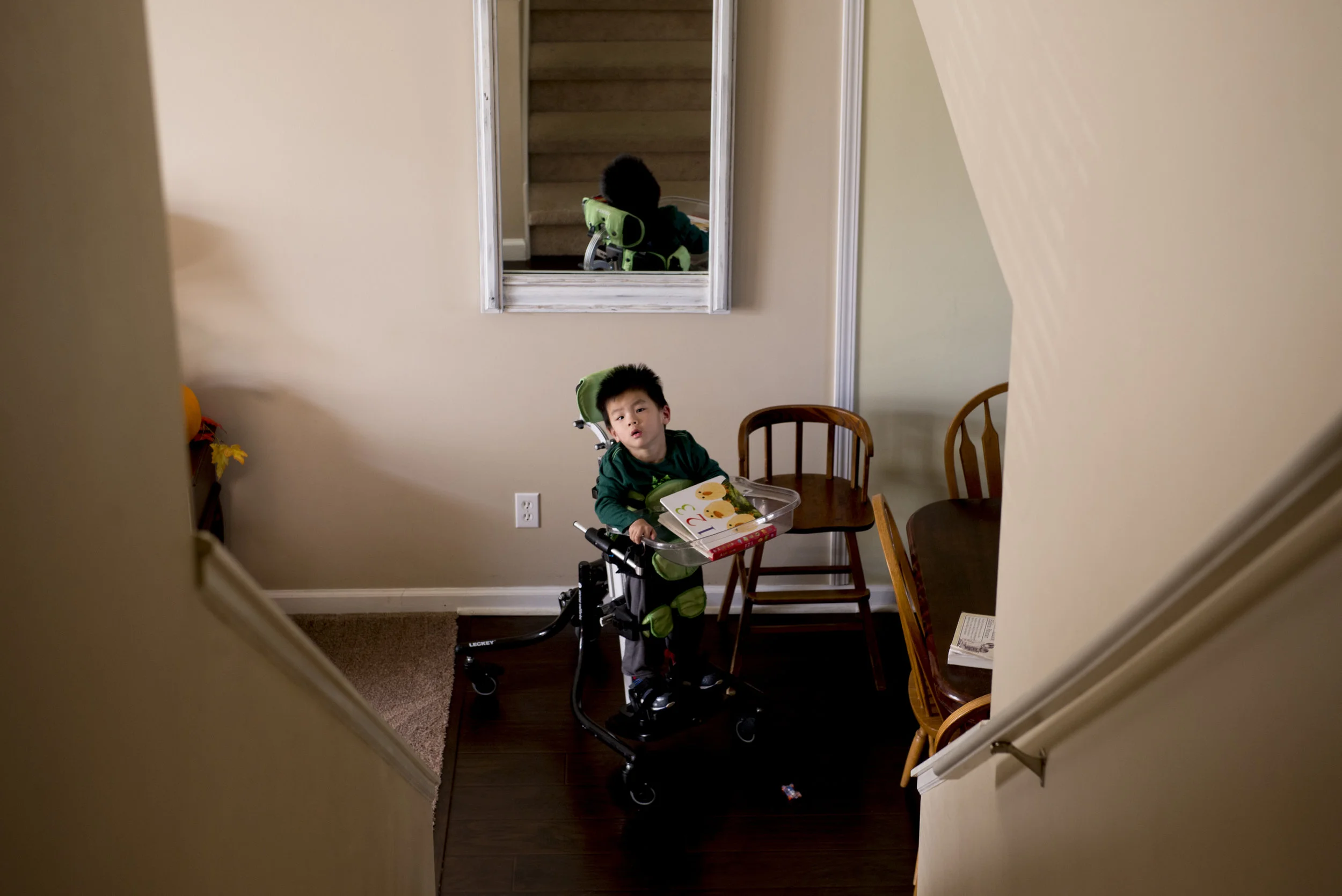  Arthur Compton, 3, looks up the stares of his home. A year ago, he and his brother Philip were adopted from China. Both have different forms of cerebral palsy. 