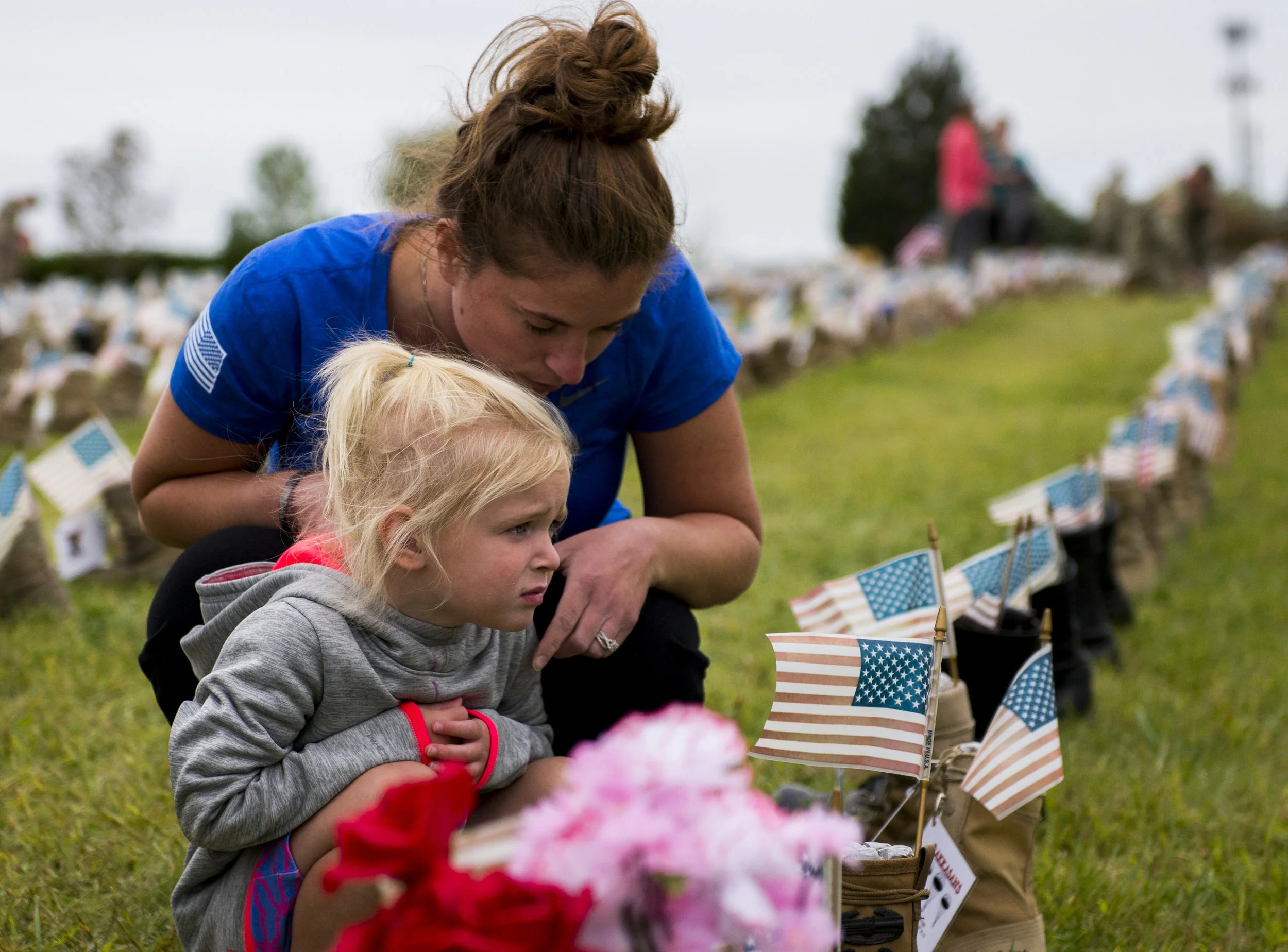  Samantha Houck, wife of Sgt. Eric M. Houck, and her daughter Violet kneel by his boot during a ceremony for fallen soldiers at Fort Campbell on September 11, 2017. Houck was one of three Rakkasan soldiers killed June 10 in northeastern Afghanistan b