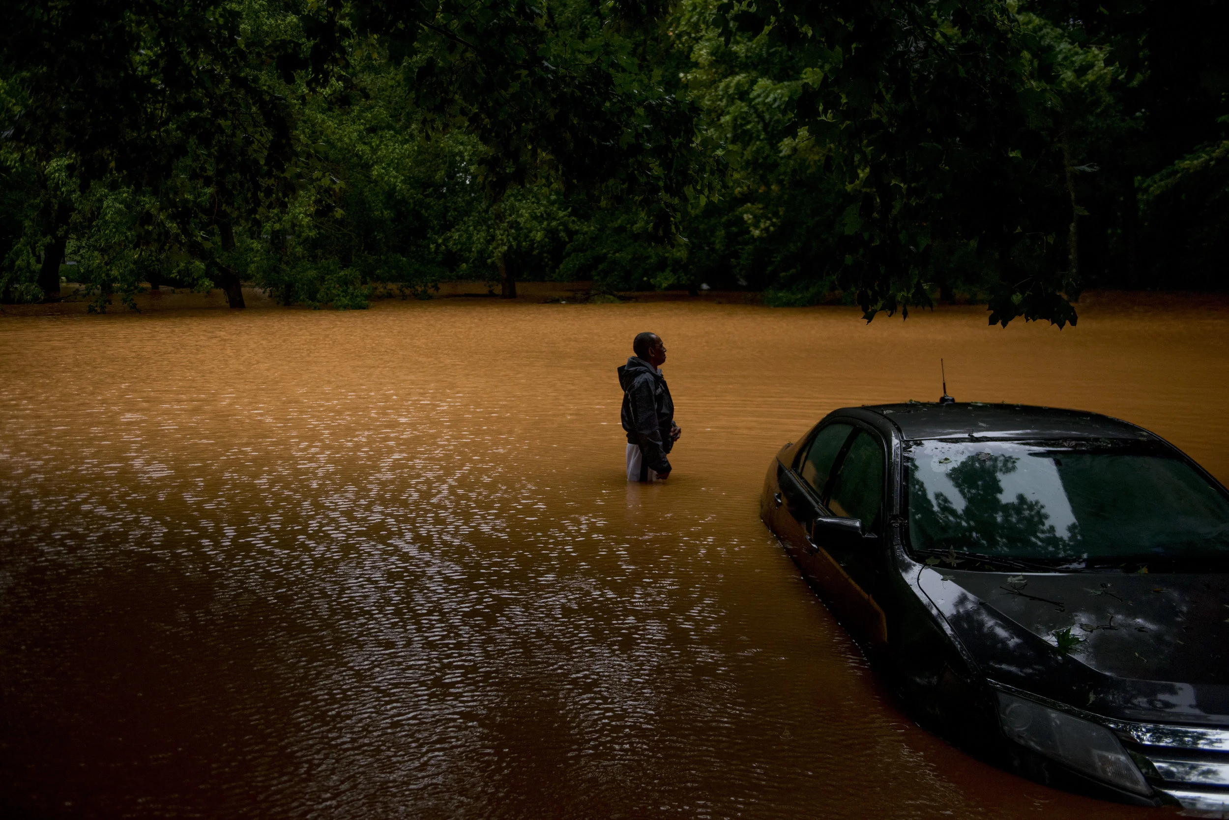  Willie Dunlap stands in his backyard next to his submerged car in Clarksville looking out at the floodwater on September 1, 2017.&nbsp; 