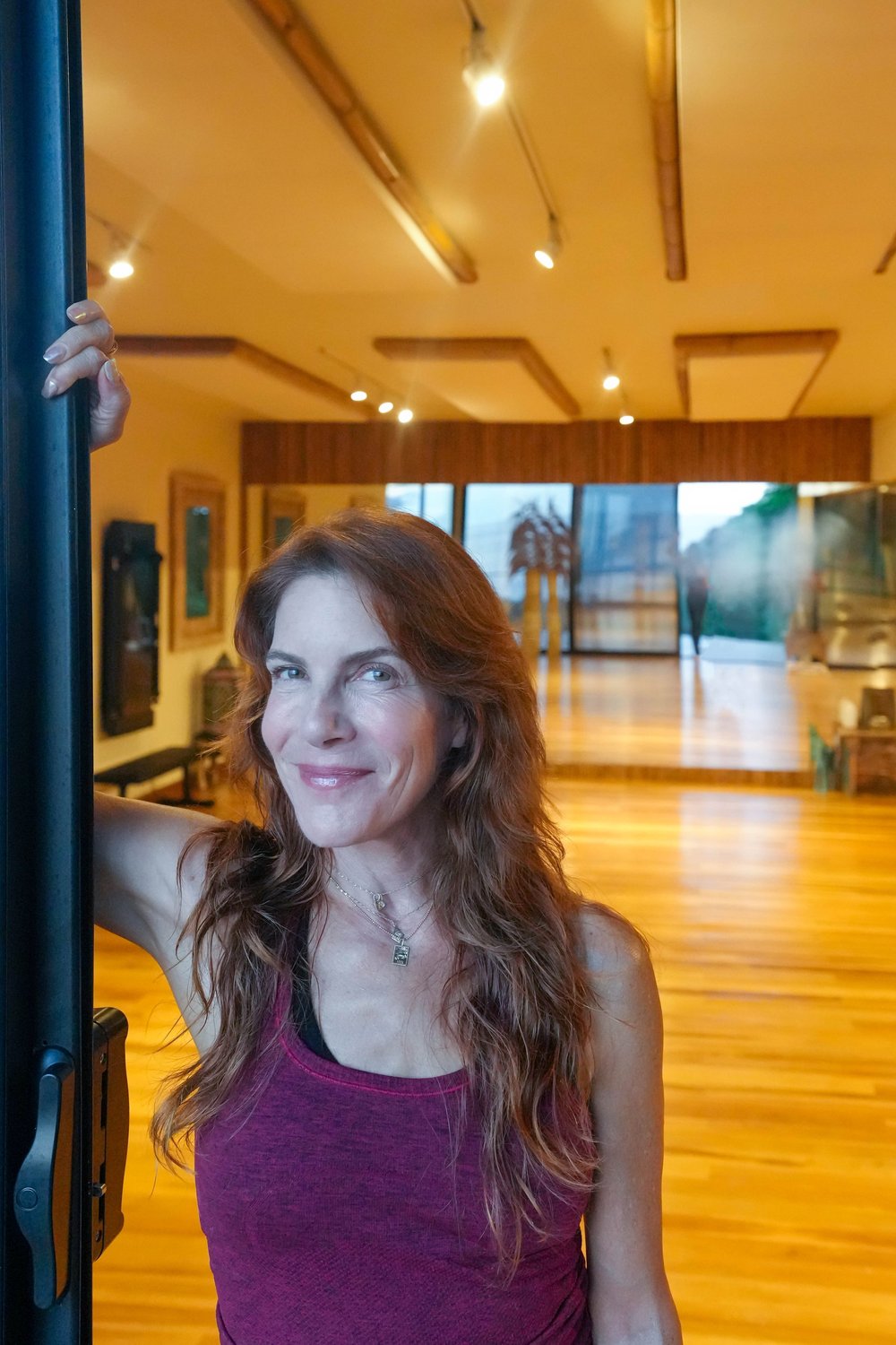 Tracy Straus smiling in a sunlit studio