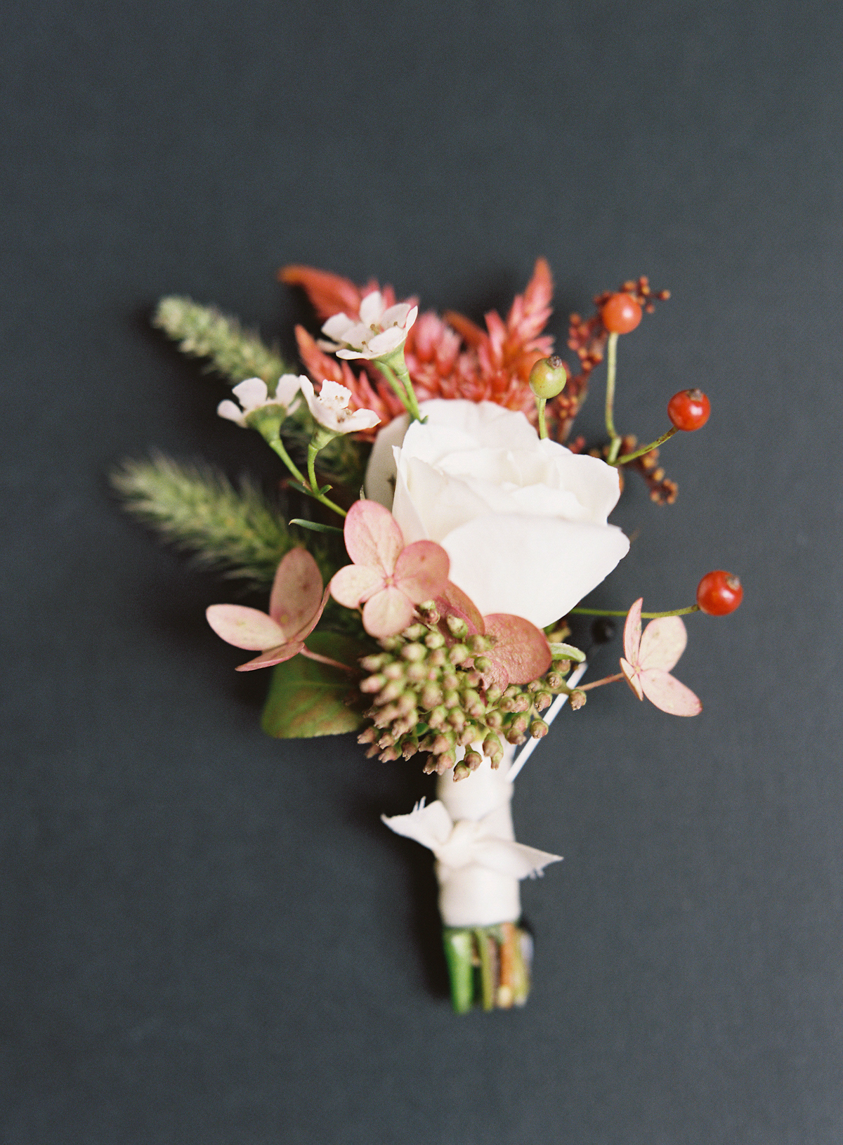 Plaza wedding boutonniere with rose and red berries