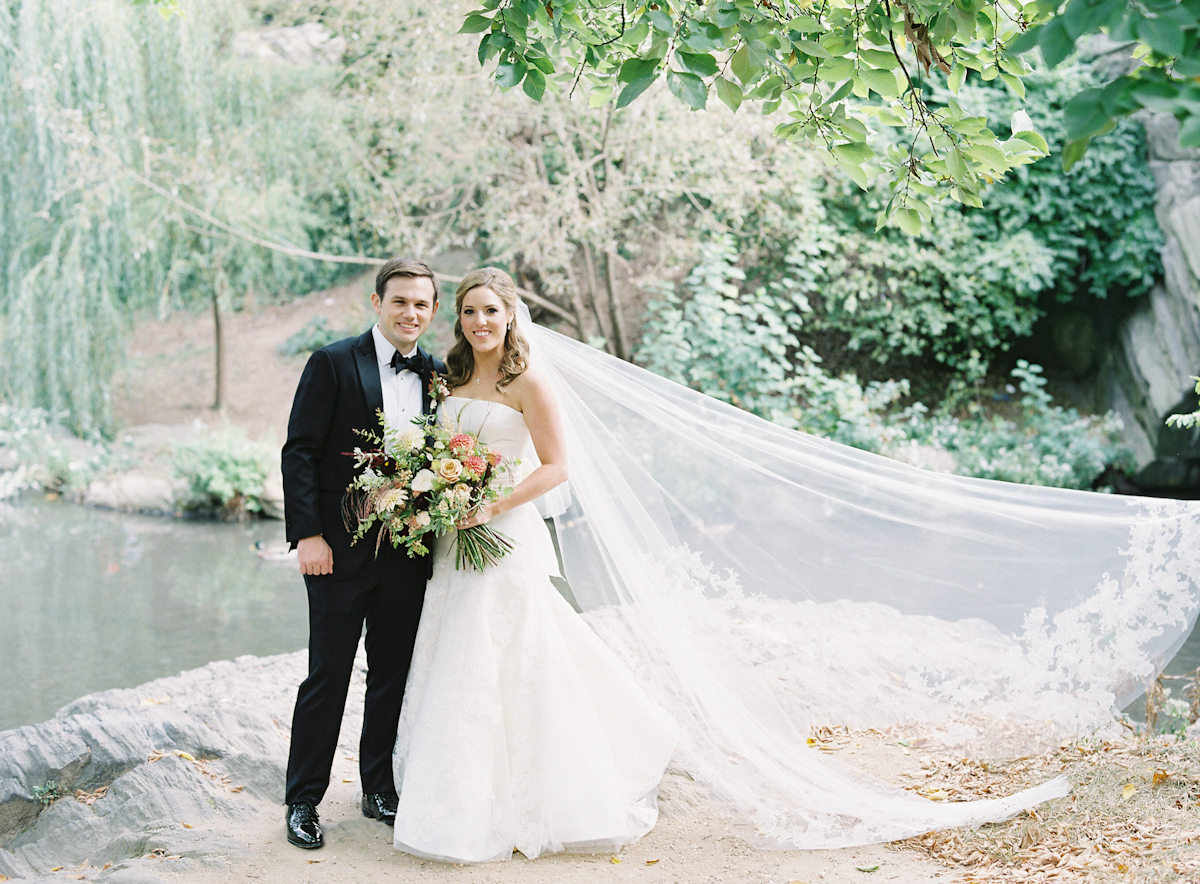 Groom and bride with long veil in Central Park