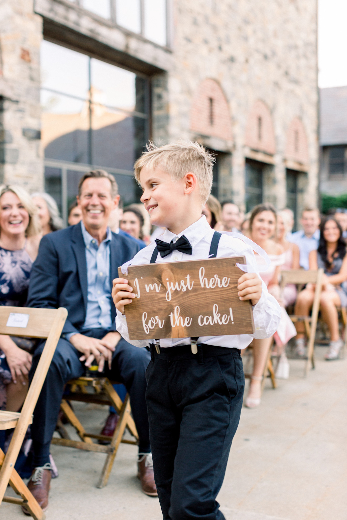Ring bearer holding wooden sign at Blue Hill at Stone Barns wedding