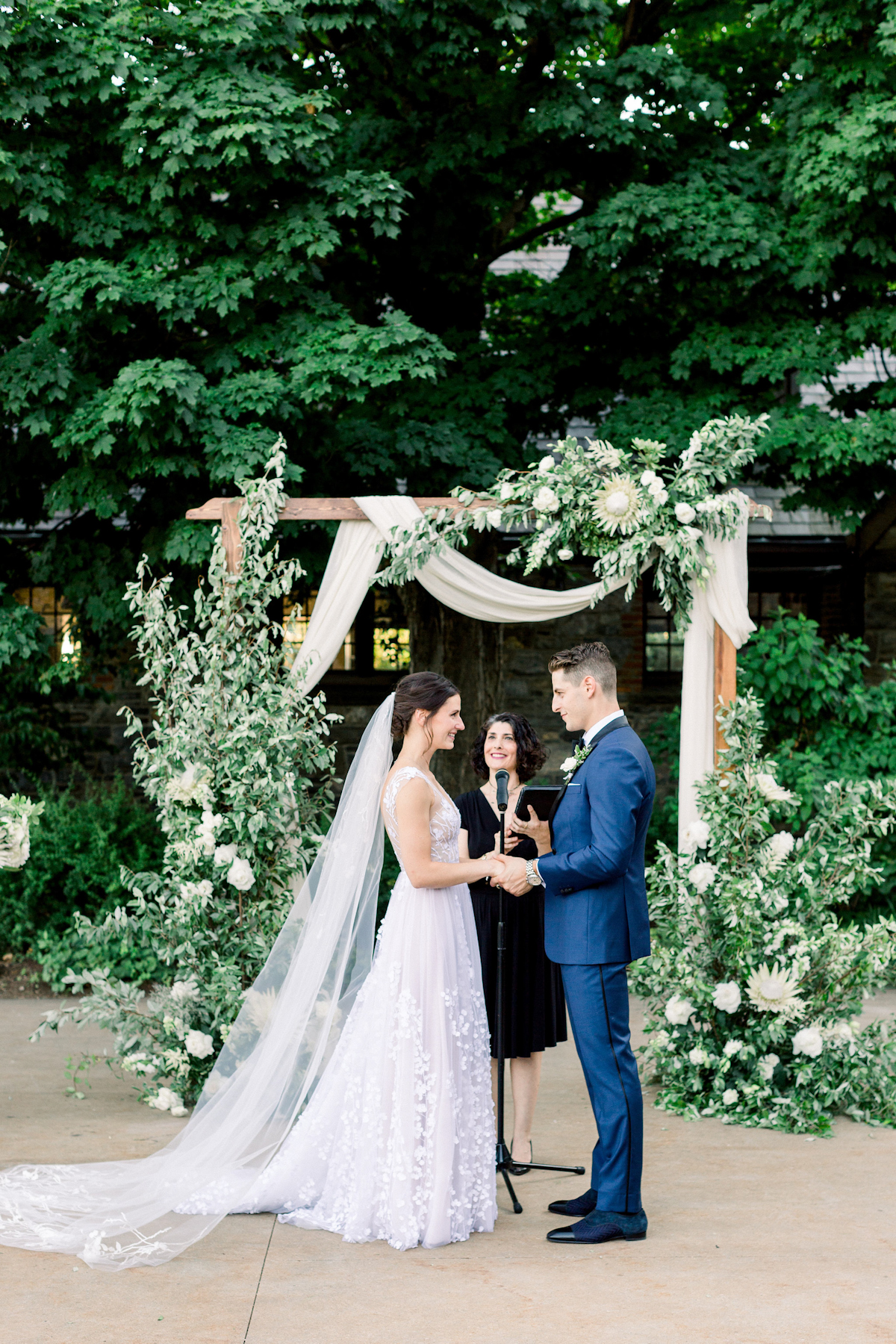 Bride and groom in front of floral arch at Blue Hill at Stone Barns wedding