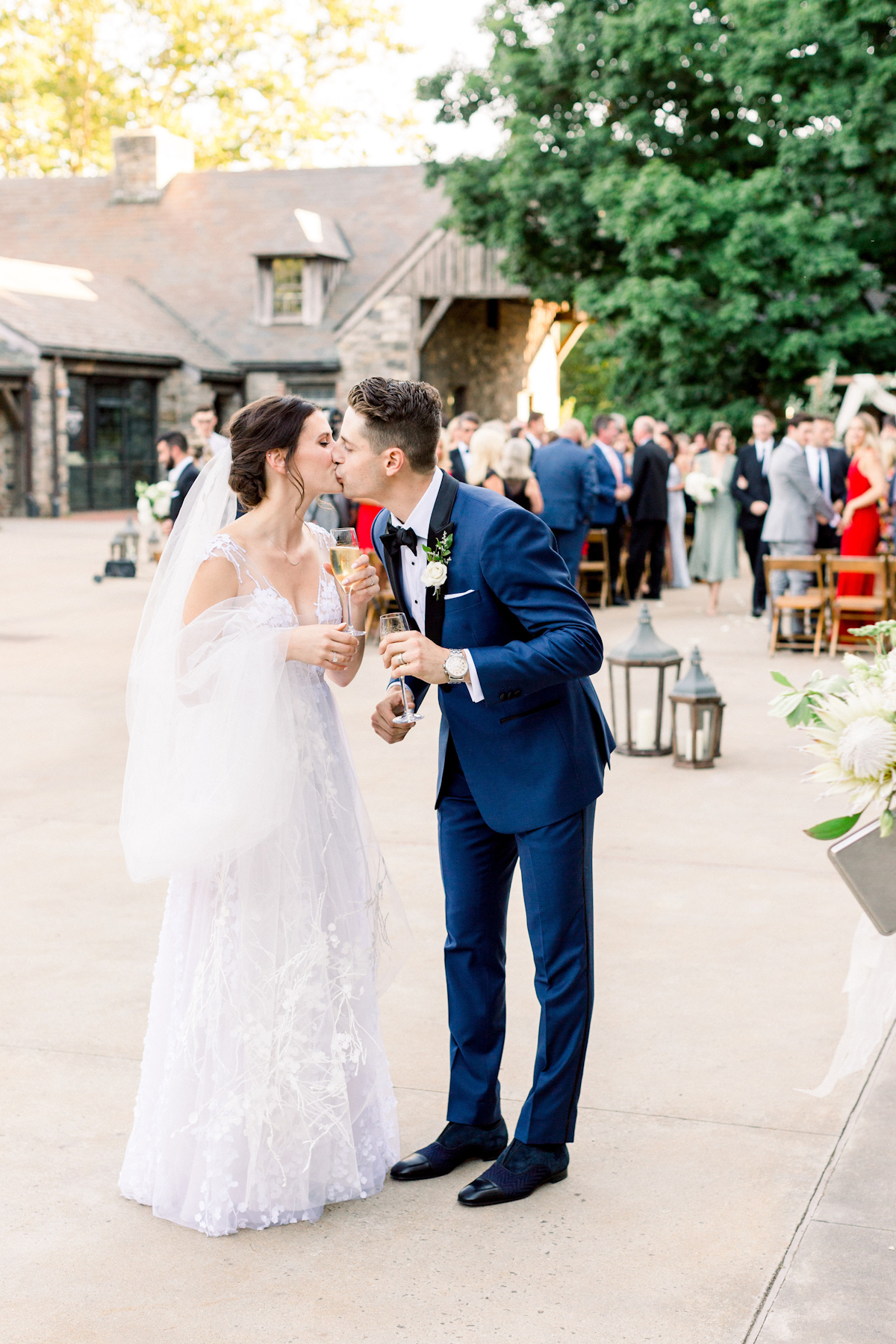 Bride and groom kissing with champagne at Blue Hill at Stone Barns wedding
