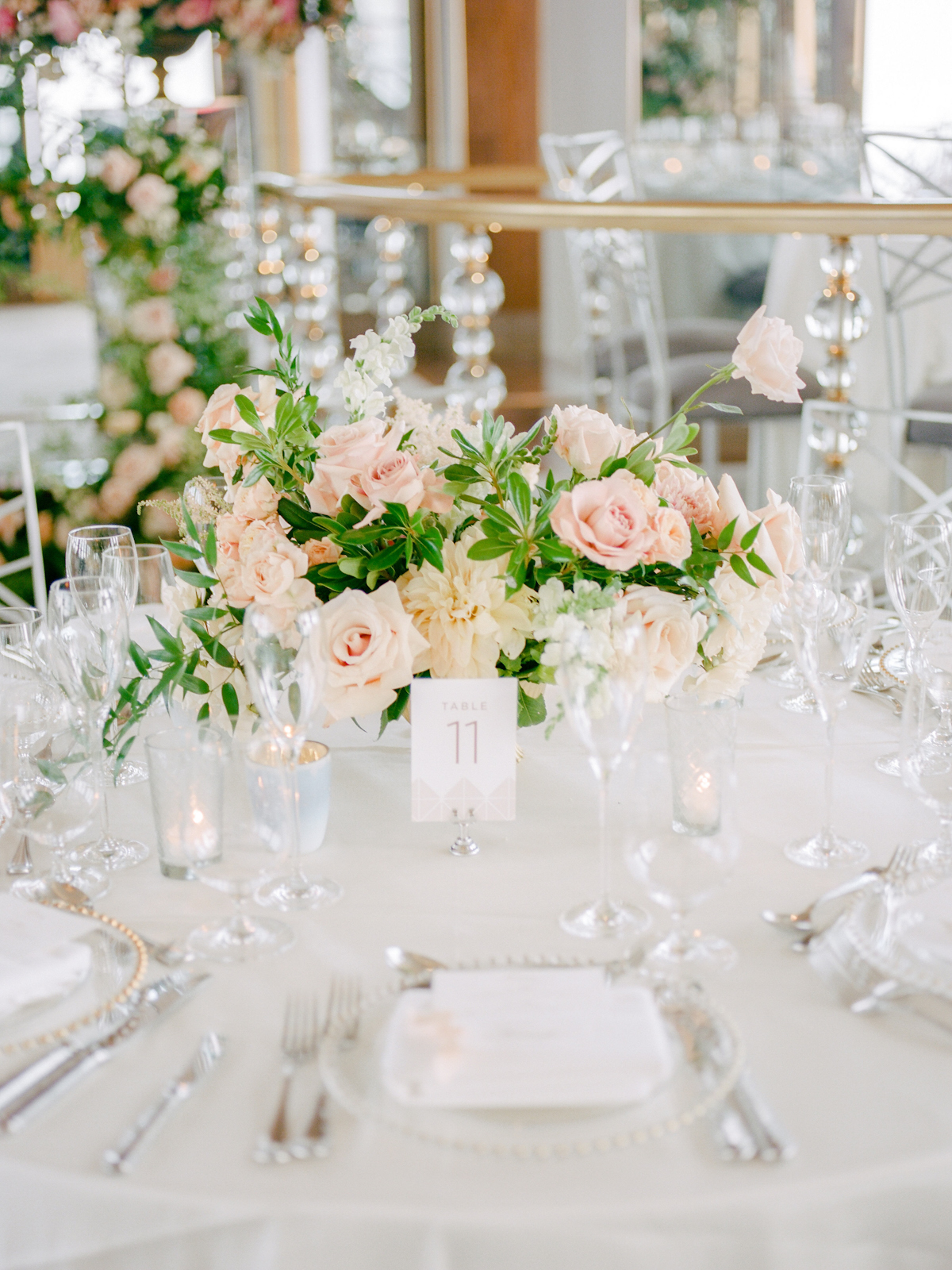Rainbow Room wedding tablescape with flowers, votives, menus and vellum place cards