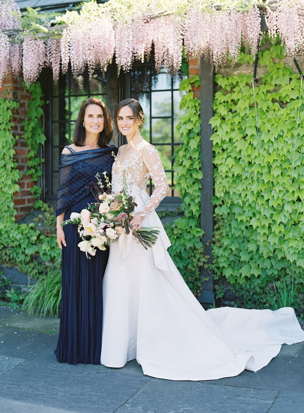 Blue Hill at Stone Barns Wedding bride and her mom standing under wisteria