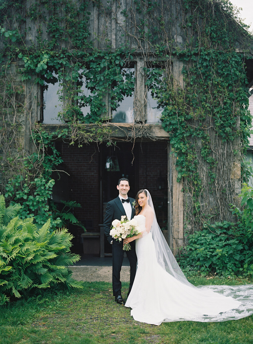 Blue Hill at Stone Barns wedding bride and groom in front of ivy manure shed