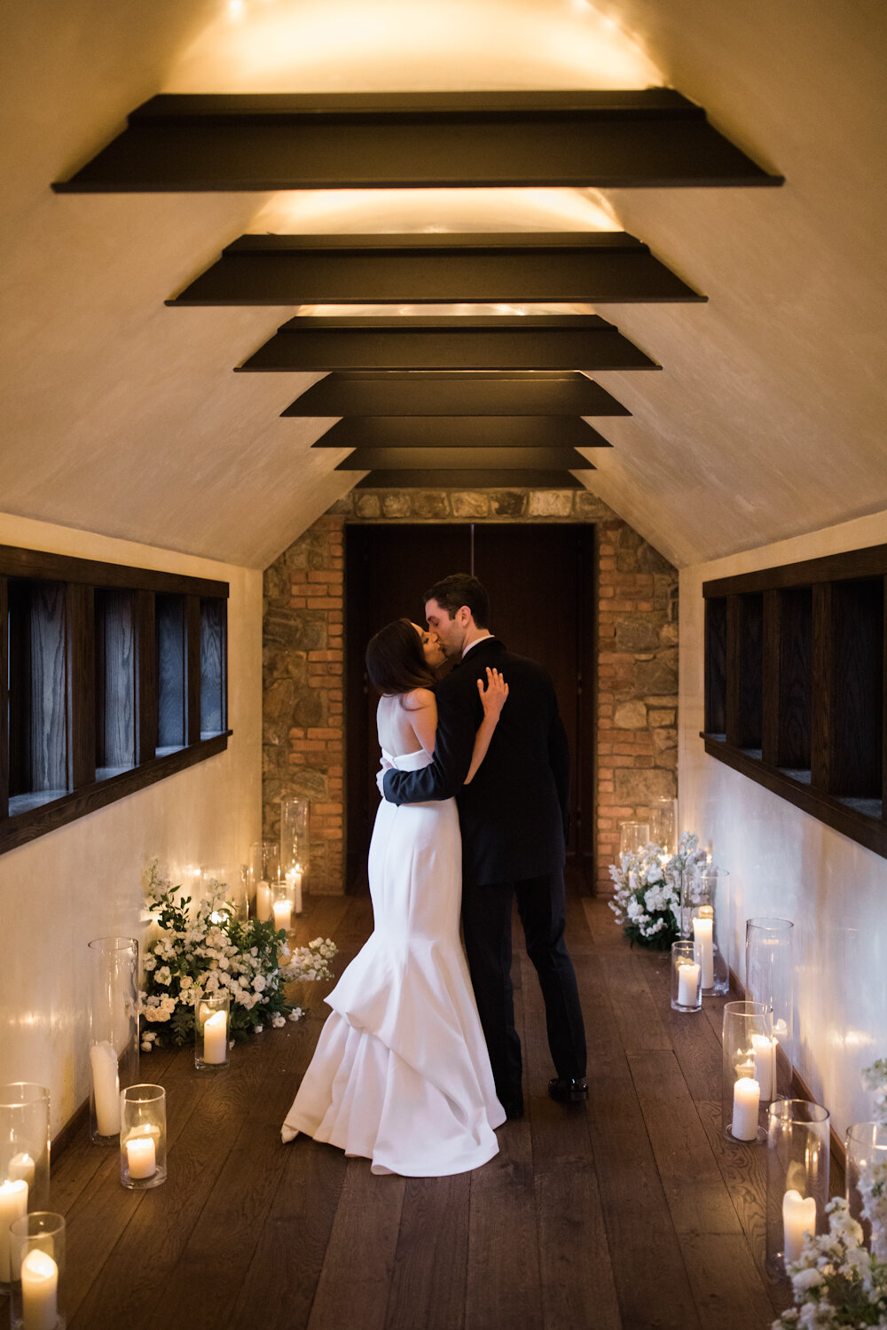 Blue Hill at Stone Barns wedding bride and groom embrace in candle lined hallway