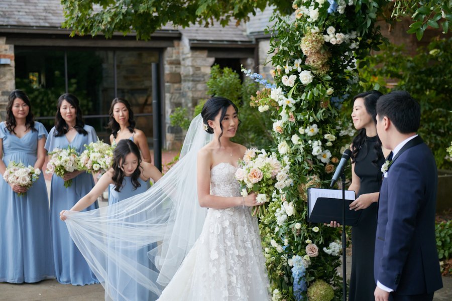blue hill at stone barns wedding ceremony bridesmaids fixing veil
