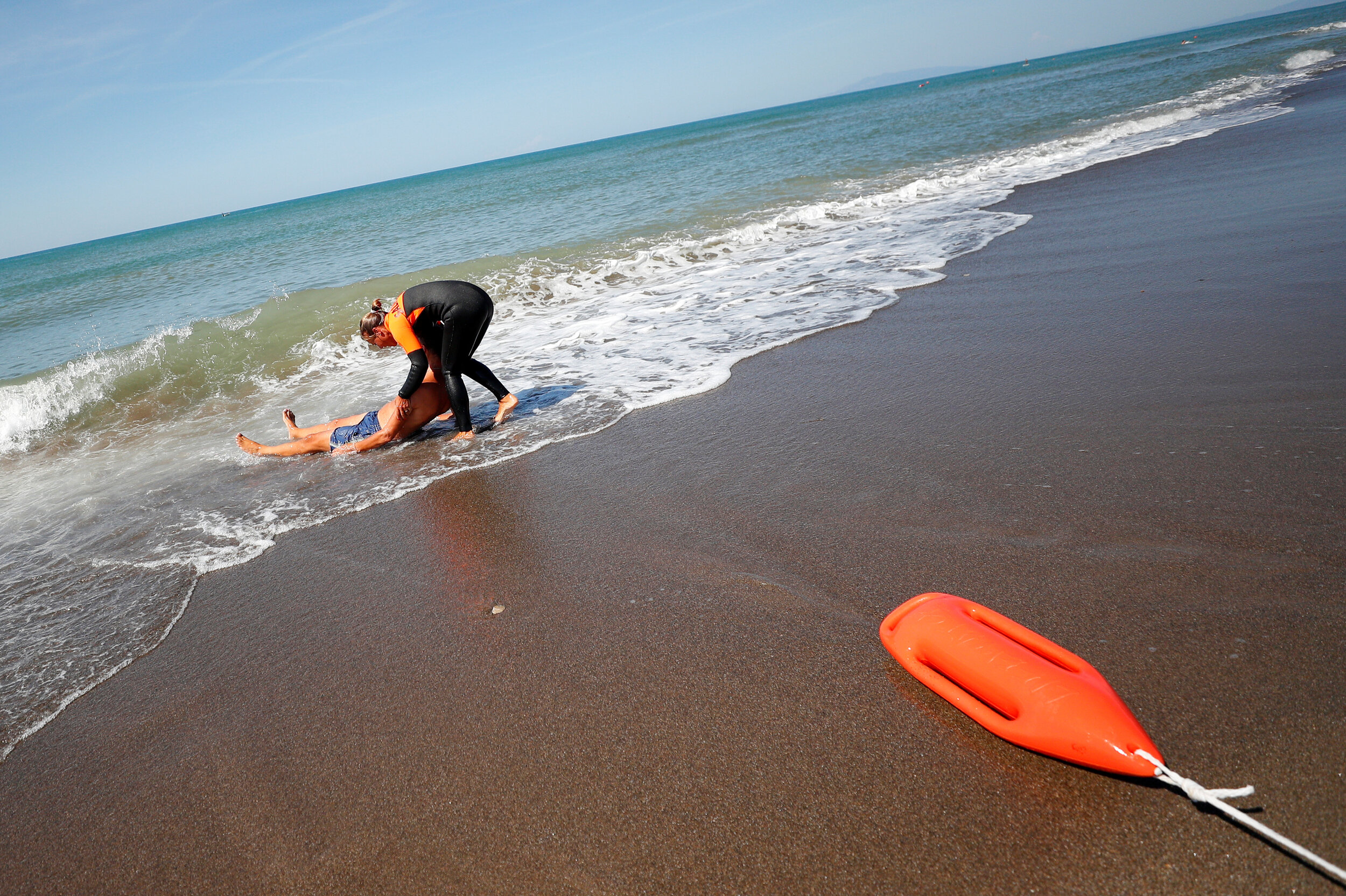  A member of an all-female group of canine rescuers from the Italian School of Rescue Dogs (La Scuola Italiana Cani Salvataggio) attends a training session with her dog before patrolling the beach to ensure swimmers can enjoy their time at the sea in