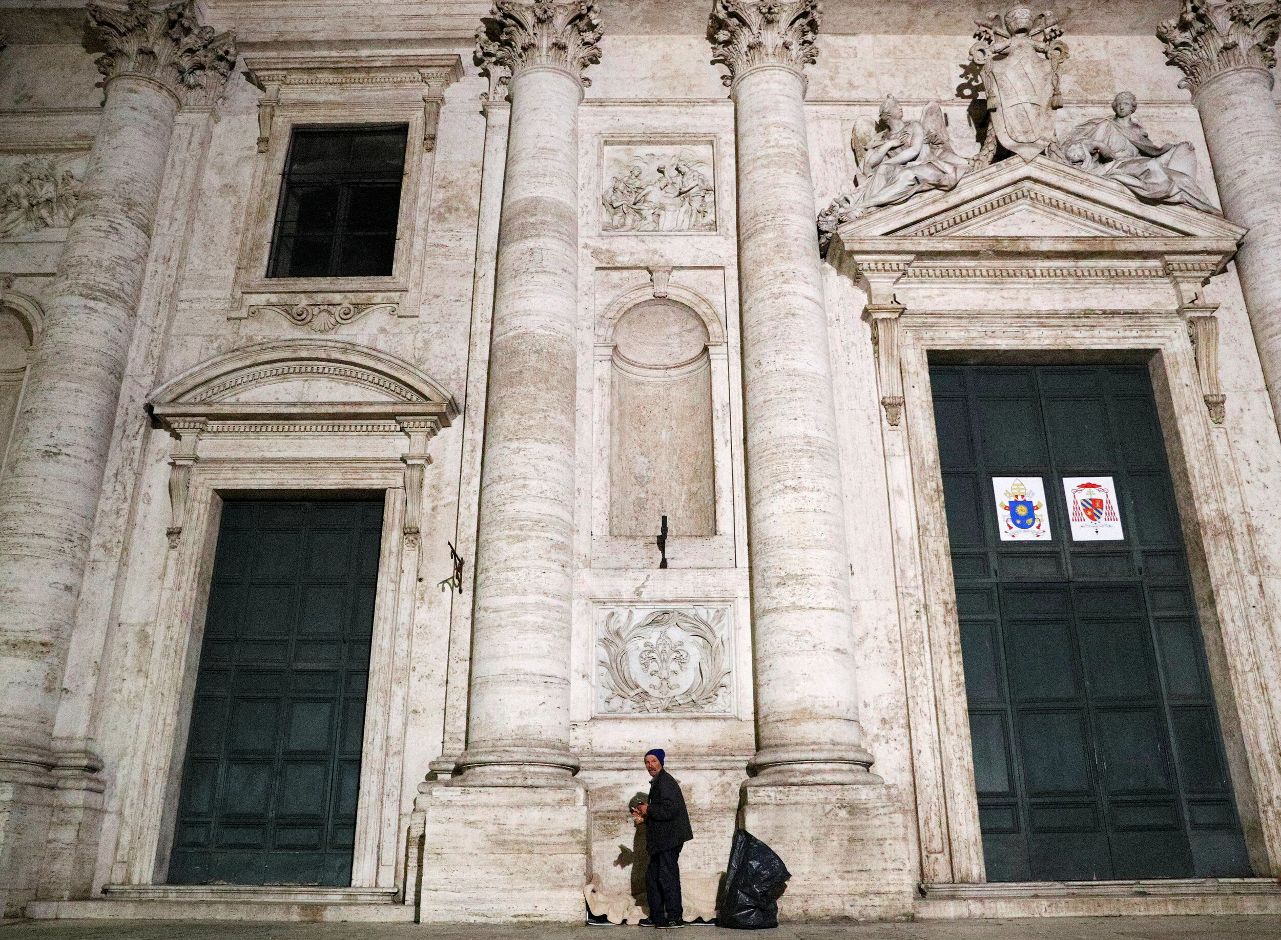  A homeless person stands outside a church in Rome, Italy, March 17, 2020. Since the coronavirus crisis, Red Cross workers have been increasing their daily activities to meet the growing needs of the homeless in Rome. 