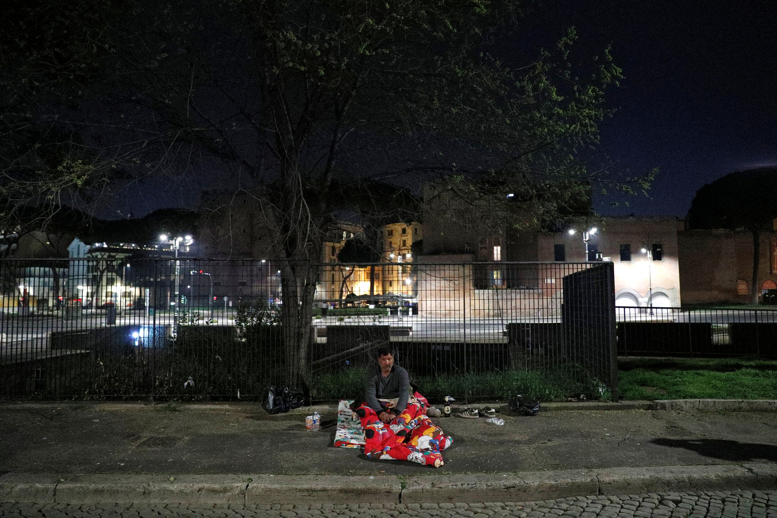  A homeless person sits on a pavement in Rome, Italy, March 17, 2020. Since the coronavirus crisis, Red Cross workers have been increasing their daily activities to meet the growing needs of the homeless in Rome.  