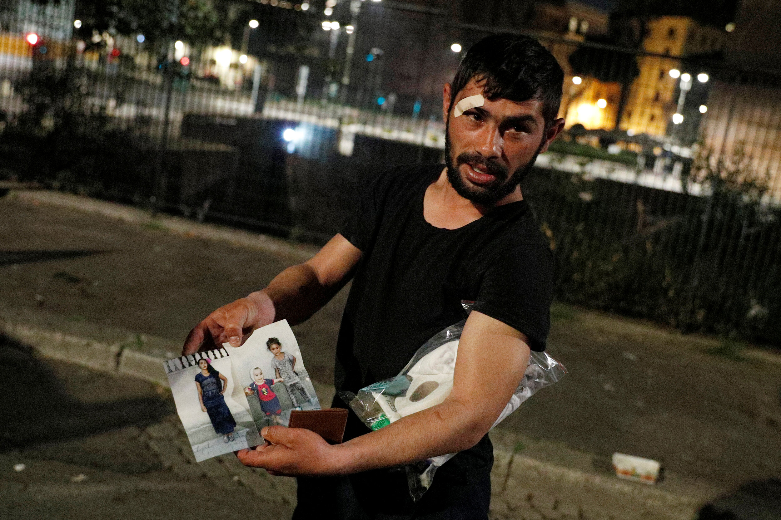  A homeless person shows pictures of his three daughters in Rome, Italy, March 17, 2020. Since the coronavirus crisis, Red Cross workers have been increasing their daily activities to meet the growing needs of the homeless in Rome.  