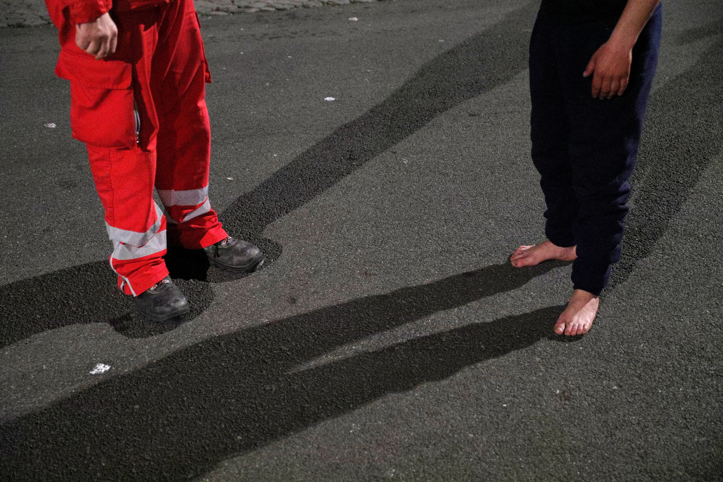  A barefoot homeless person stands next to a Red Cross worker in Rome, Italy, March 17, 2020. Since the coronavirus crisis, Red Cross workers have been increasing their daily activities to meet the growing needs of the homeless in Rome.  