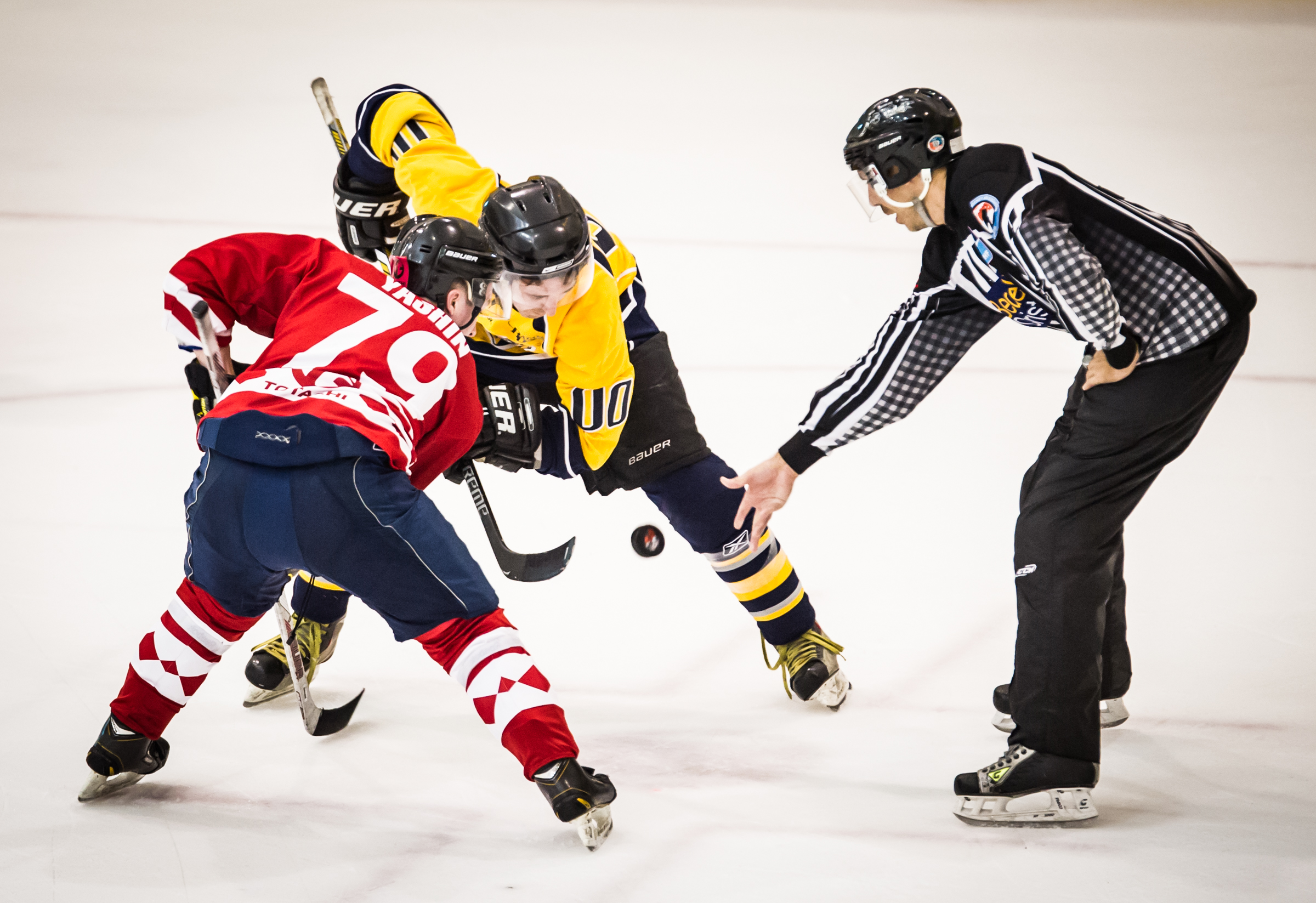 Two players face off as the referee drops the puck during the Lion City Cup at the Rink.