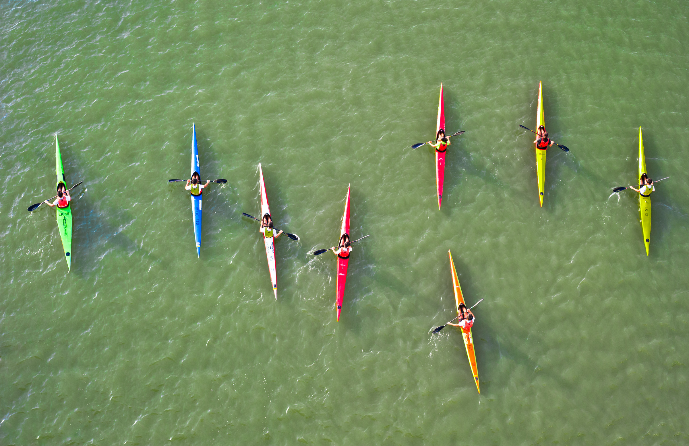 Kayaks paddle through the algae bloom at the Marina Channel.